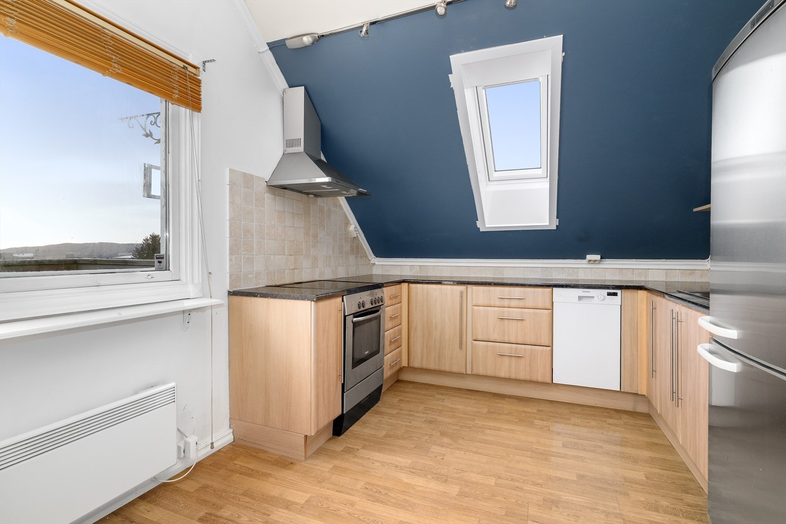 Det er avsatt plass til frittstående oppvaskmaskin, komfyr og kjøl/fryseskap, og over kokesonen er det ventilator med avtrekk ut. Galleribilde