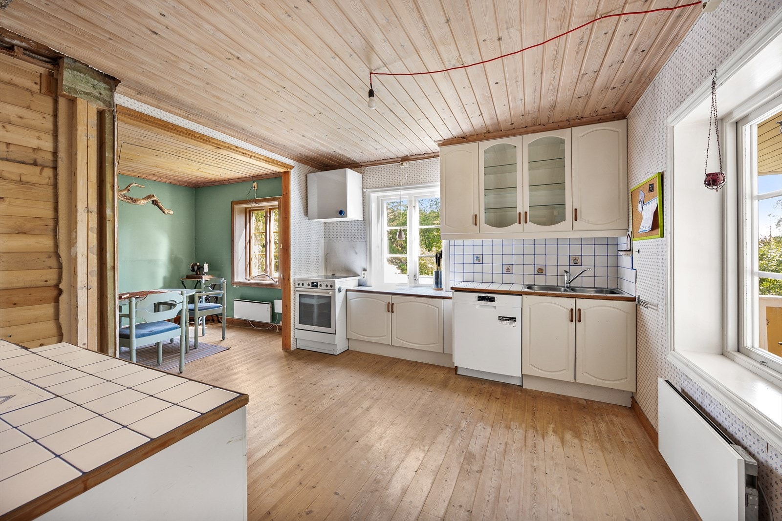 Innredningen har kremhvite fronter, flislagte benkeplater og oppvaskkum. Galleribilde