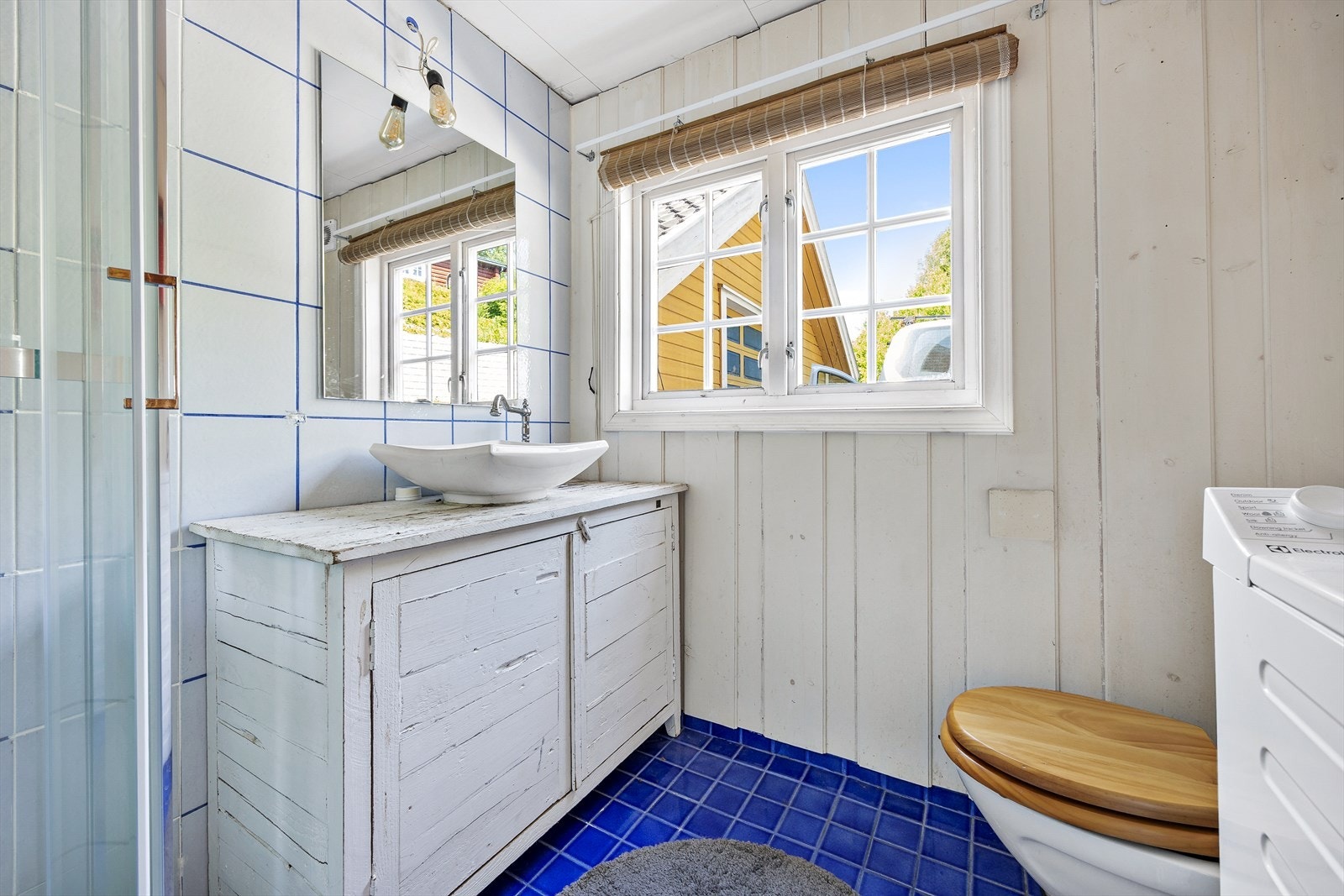 Videre har badet gulvmontert toalett, dusjkabinett, opplegg for vaskemaskin og lun gulvvarme. Galleribilde