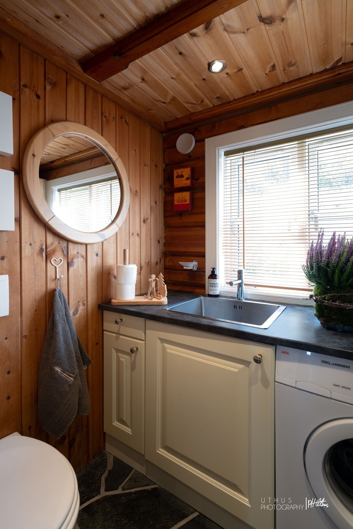 Vaskerom med innredning, høyskap, servant og opplegg for vaskemaskin. Galleribilde