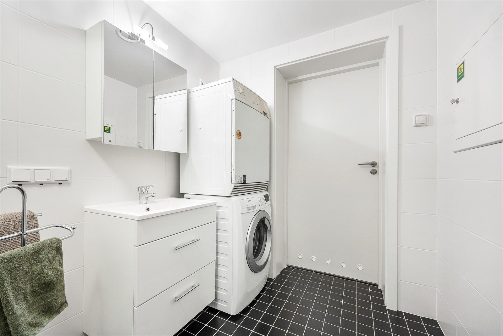 Badet er utstyrt med servant i baderomsinnredning, speilskap med belysning over, veggmontert toalett og dusjhjørne. Galleribilde