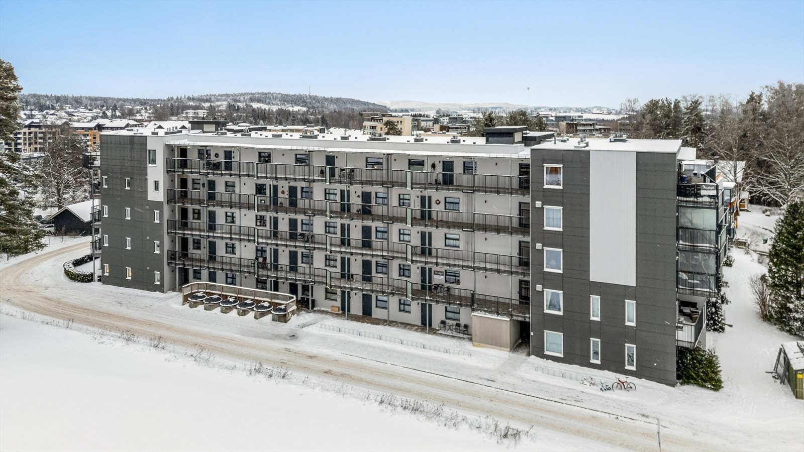 Fasade. Asfaltert adkomst til blokken, samt gjesteparkering og sykkelparkering. Galleribilde