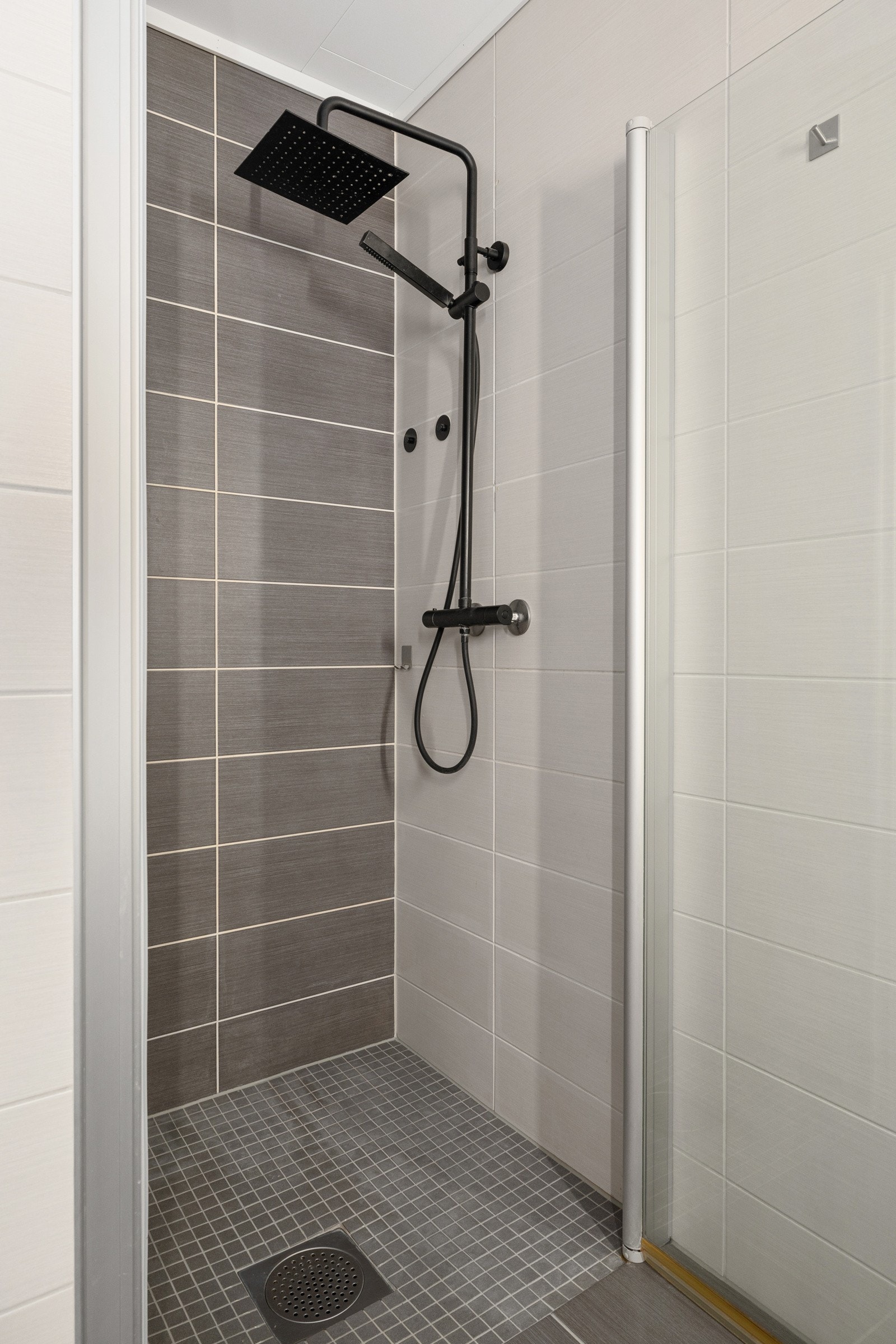 Innredet med baderomsinnredning, høyskap, vegghengt toalett og dusjnisje. Galleribilde