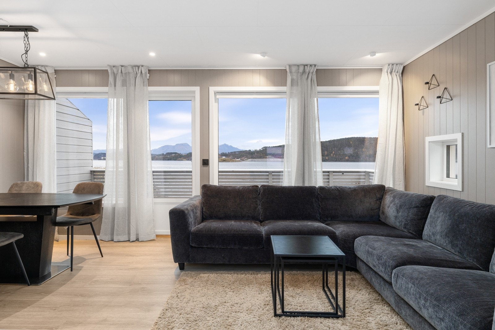 Store vindusflater som gir mye naturlig lysinnslipp og en romslig følelse i stuen. Galleribilde