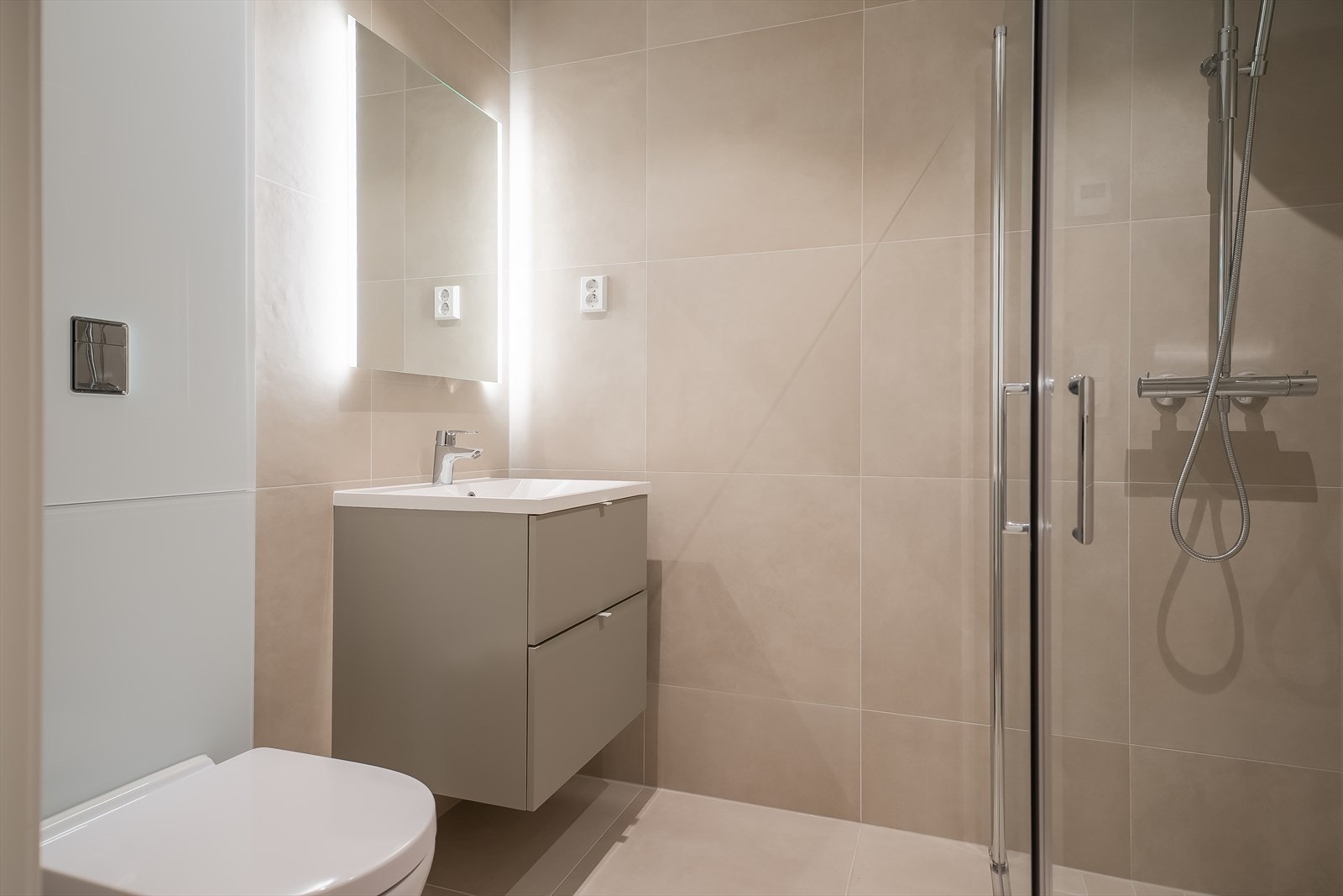 Gjestebad på 3,5m² i samme stil som masterbadet med 60x60 fliser og gulvvarme. Galleribilde