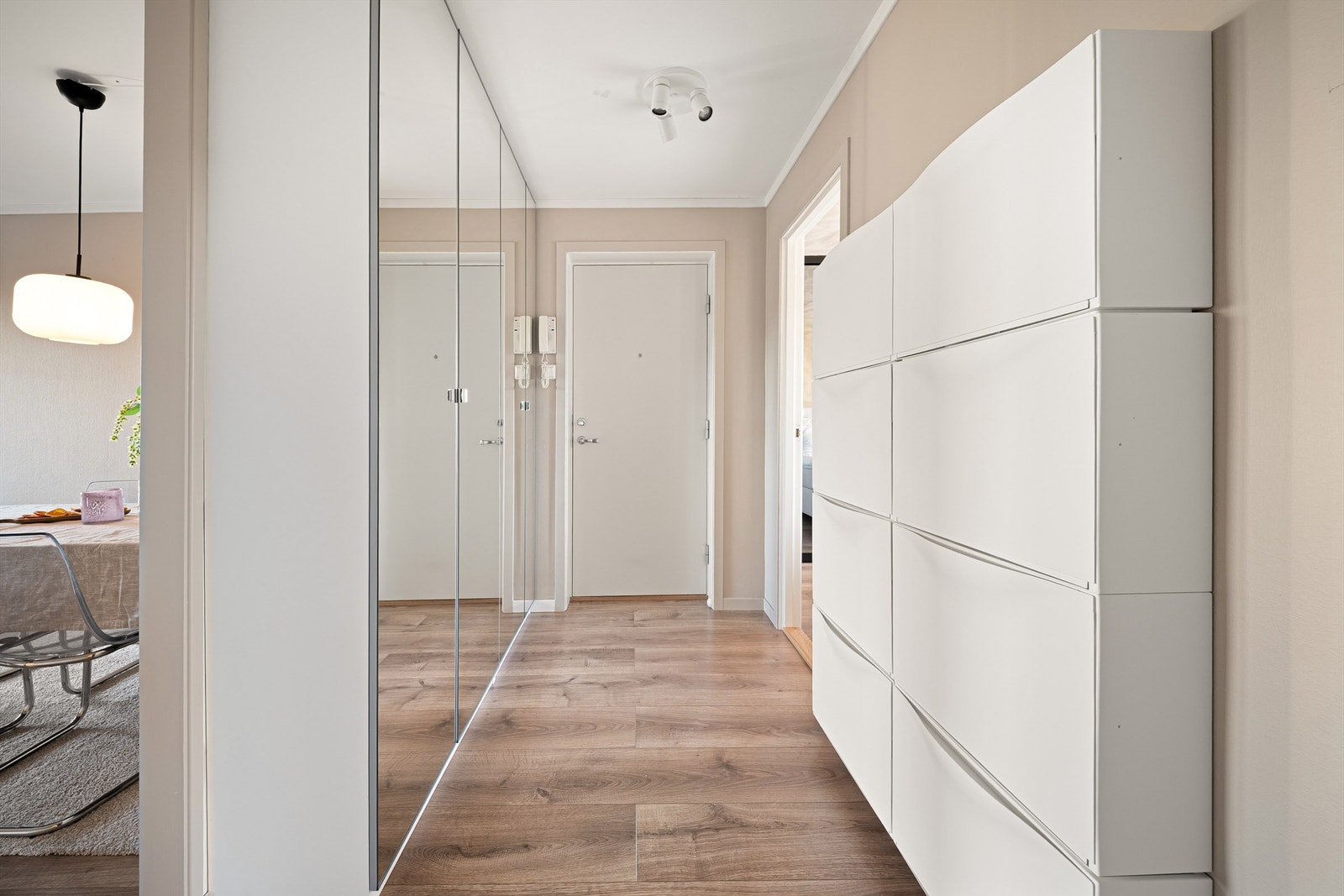 Entreens rekke av takhøyde garderobeskap har praktiske speilfronter som utvider romfølelsen. Galleribilde