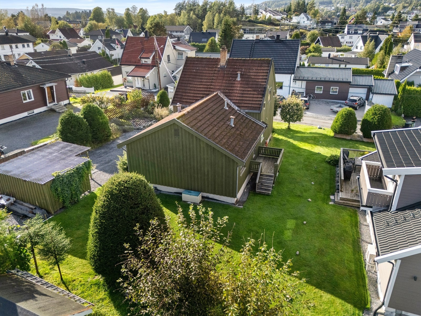 Tomten er opparbeidet med plen og beplantning, og grenser mot andre eneboliger. Galleribilde