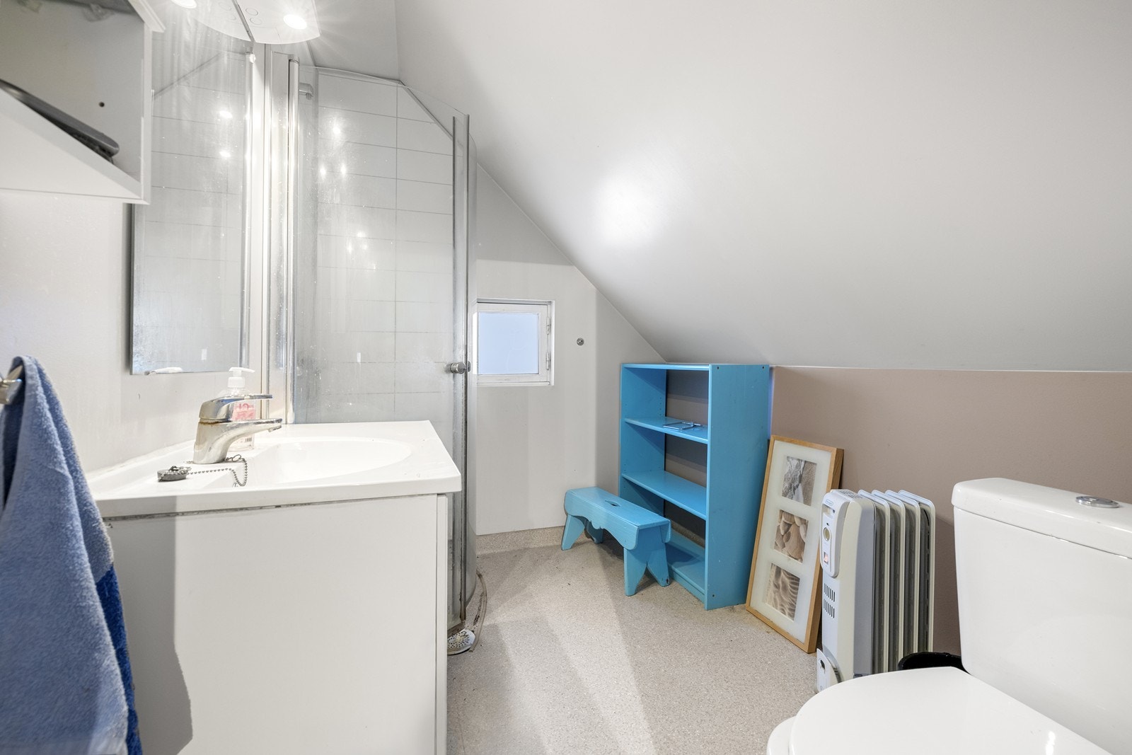 Baderom med belegg på gulv. Badet innehar servant, toalett og et dusjhjørne med innfellbare glassvegger. Galleribilde