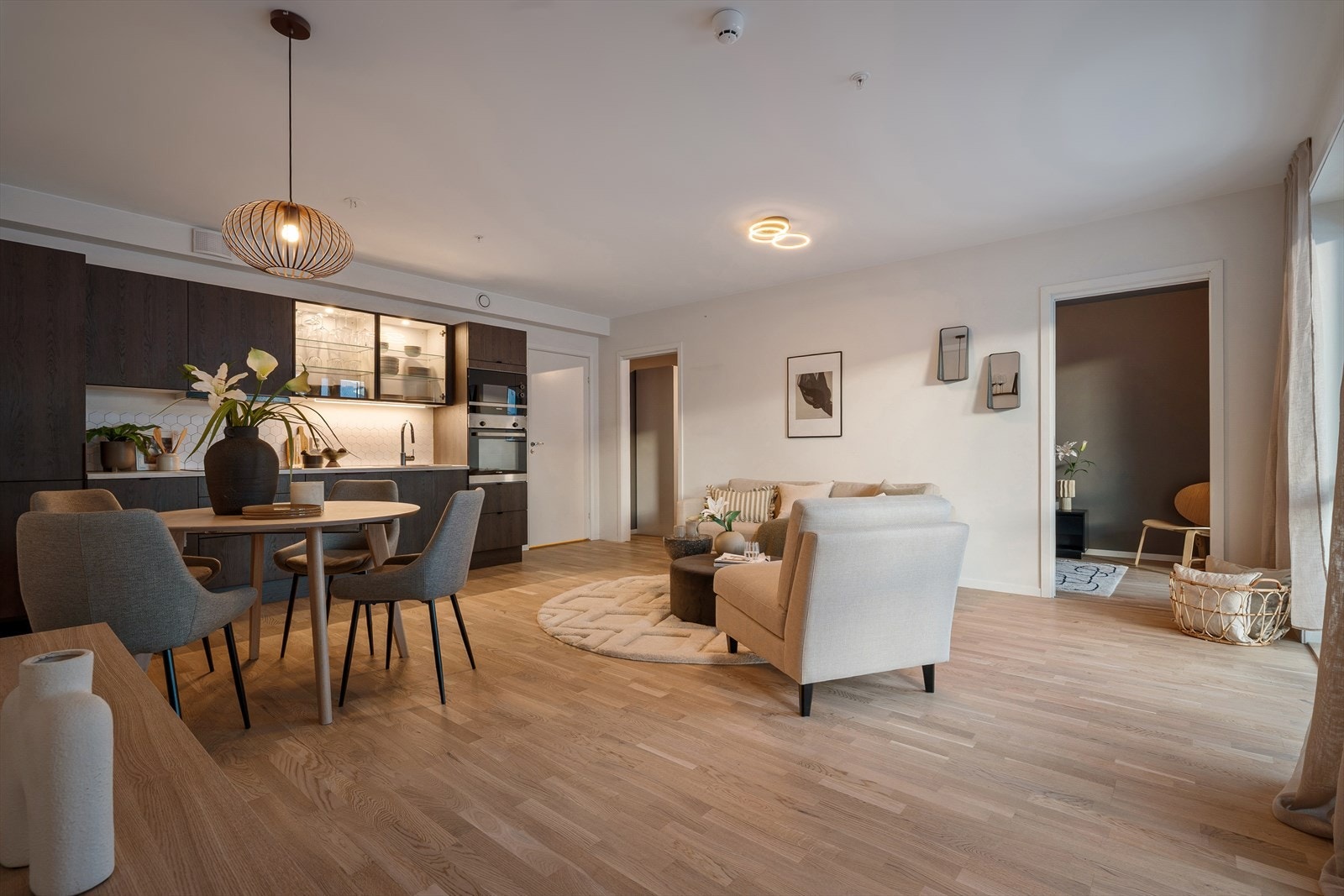 Kjøkkenet fremstår delikat og moderne med stilren kjøkkeninnredning med glatte fronter, hvor to fronter med elegante glassfelt tilfører et eksklusivt preg. Galleribilde