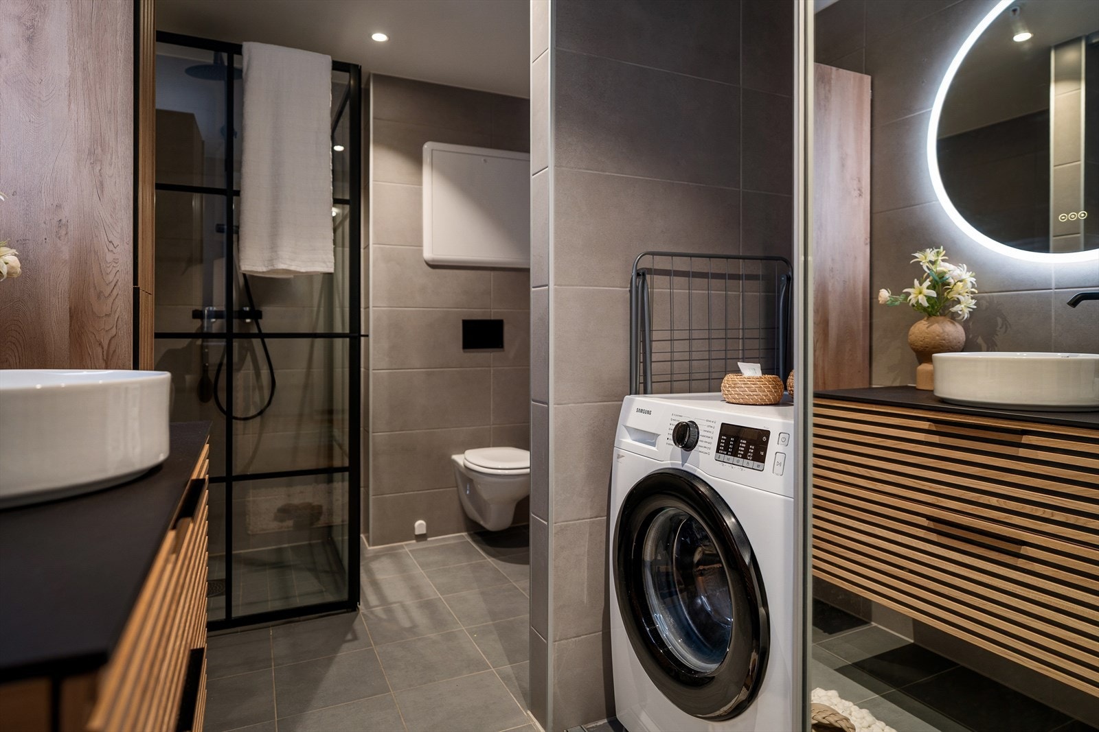 Praktisk opplegg for vaskemaskin er skjult bak skyvedører, noe som gir et ryddig og helhetlig uttrykk. Galleribilde