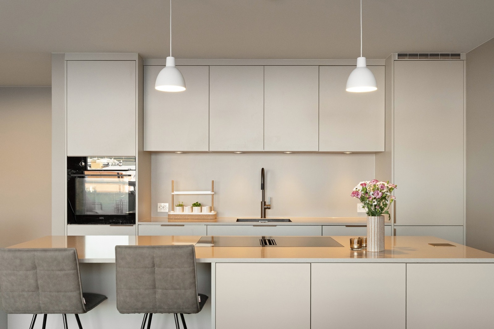 Kjøkkenøy med spiseplass og planlimt induksjonstopp og nedfelte stikkontakter. Galleribilde