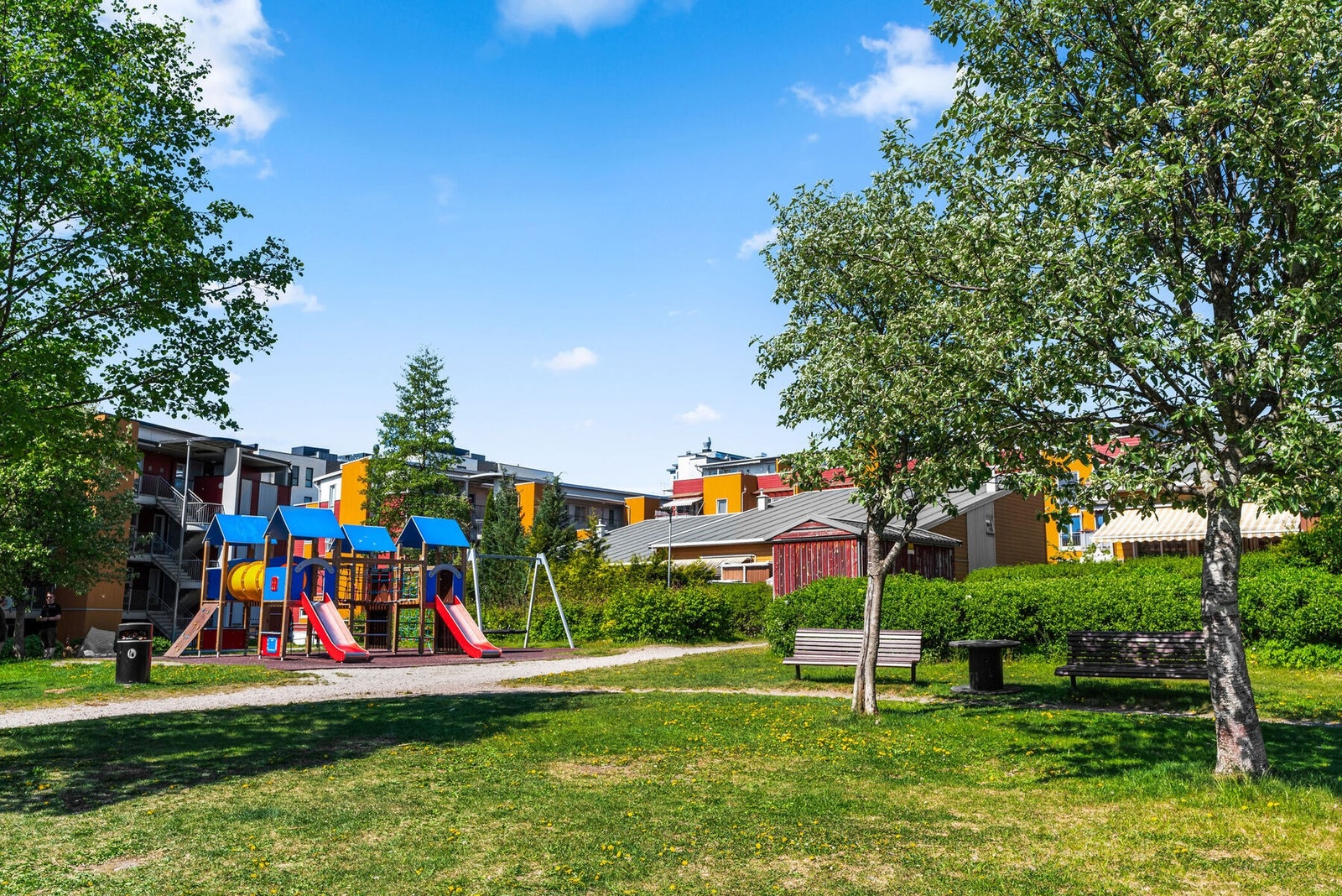 Sommerbilde av fellesarealene som har lekeplasser, sittegrupper m.m Galleribilde