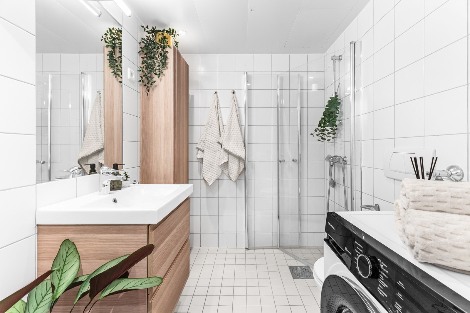 Leiligheten har et pent, flislagt bad med varmekabler i gulv og downlights i tak. Det er opplegg for vaskemaskin og tørketrommel Galleribilde