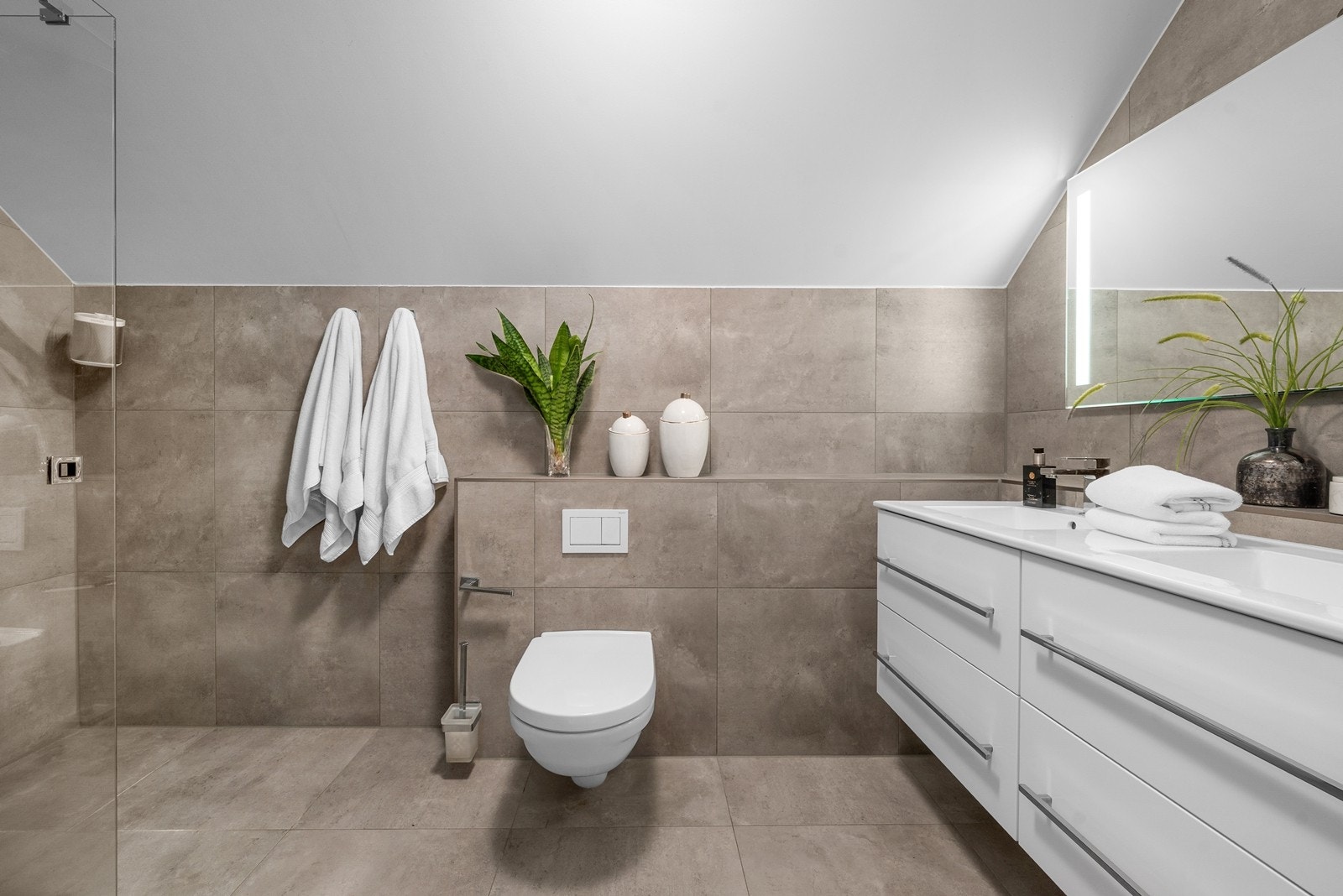 Badene har vegg- og gulvfliser i stilrent uttrykk Galleribilde