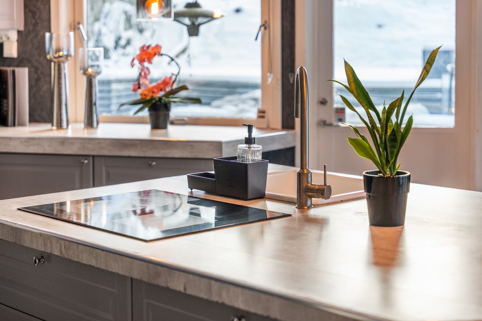 Integrert induksjon koketopp og stor nedfelt vask i laminatbenkeplate i kjøkkenøya. Galleribilde