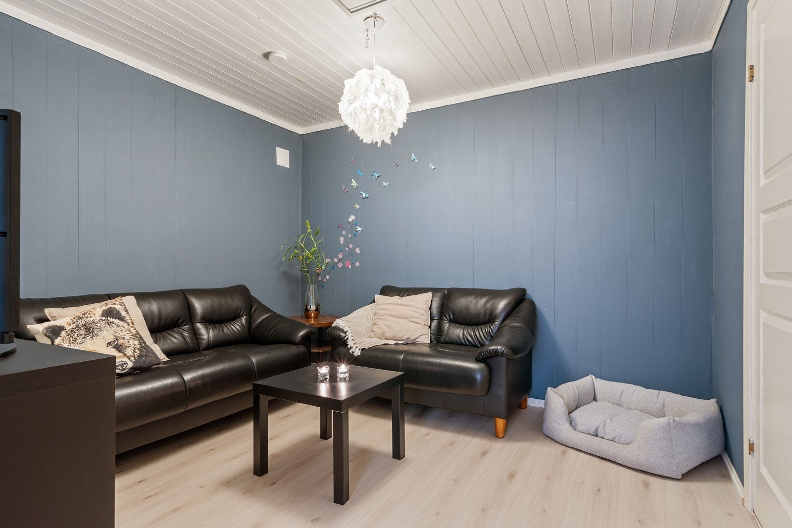 Rom uten vindu med vedovn og sofagruppe. Fungerer som en kjellerstue for eier, men er bare godkjent som en bod. Galleribilde