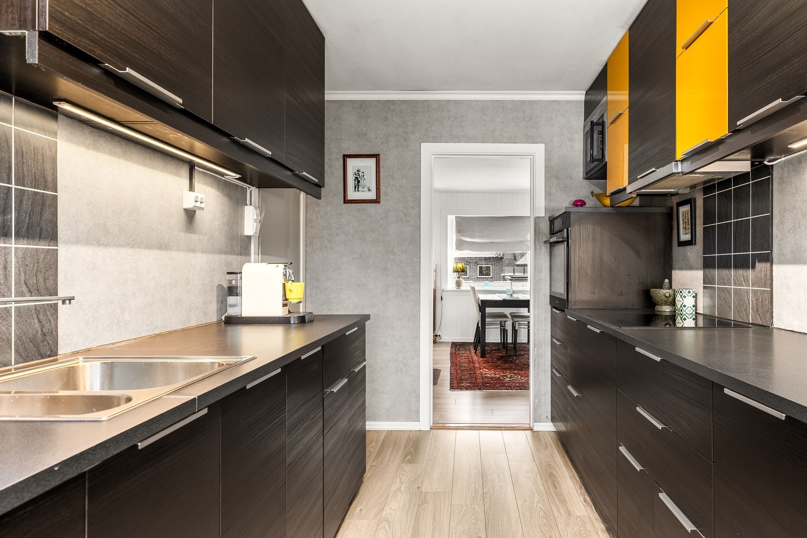 Kjøkkenet har en funksjonell parallell-løsning, integrerte hvitevarer og adkomst fra både gangen og stuen. Galleribilde