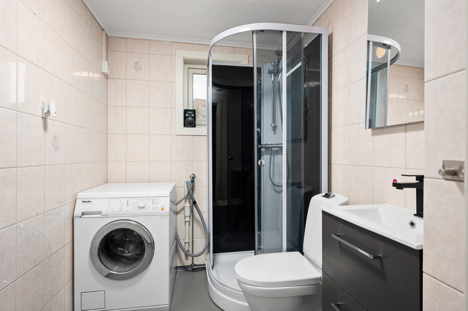 Baderom har fliser på vegger og belegg på gulv. Galleribilde