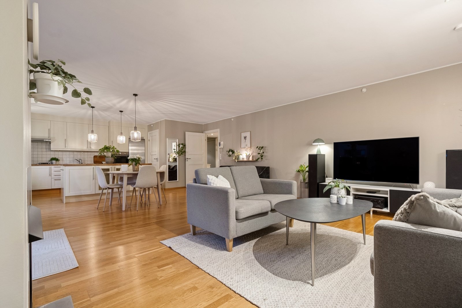 Lys og luftig stue med åpen kjøkkenløsning. God plass til både spisegruppe og sofakrok, store vinduer som gir rikelig med naturlig lys og en moderne, sosial planløsning. Galleribilde