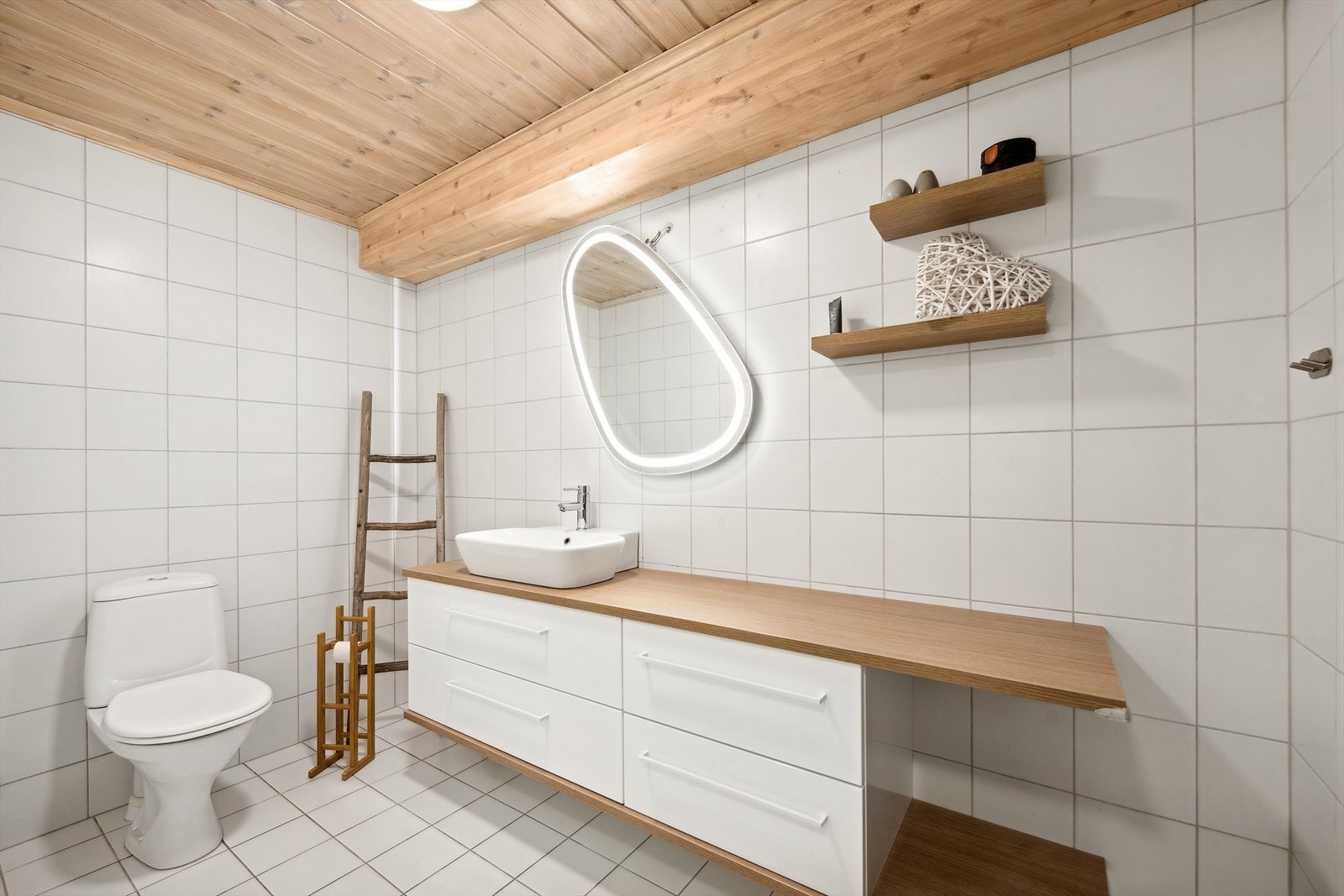 Lyst og pent flislagt baderom med pen badersomsseksjon med heldekkende vask, dusj og wc. Galleribilde