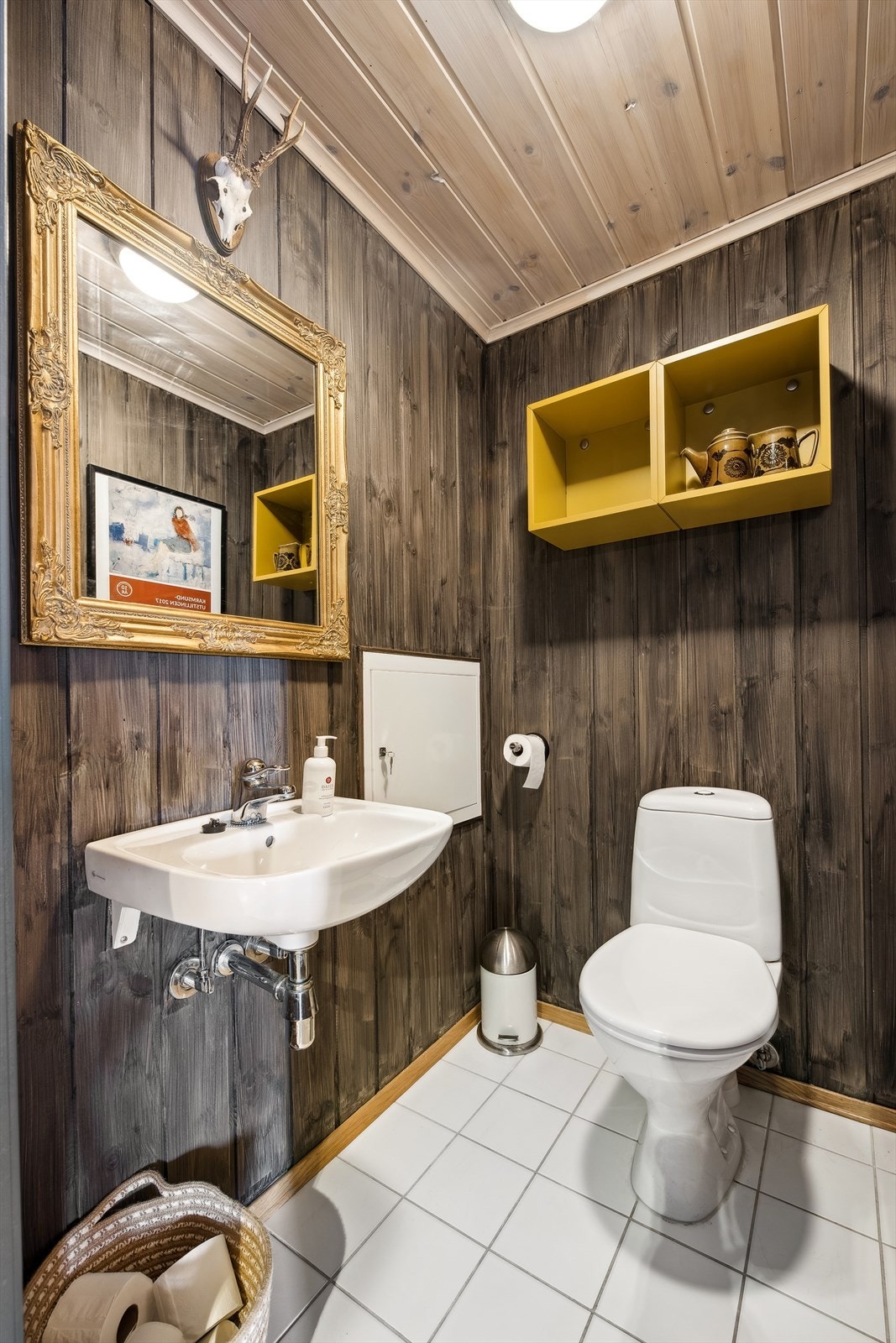 Gjestetoalett med enkel servant og fliser på gulvet. Galleribilde