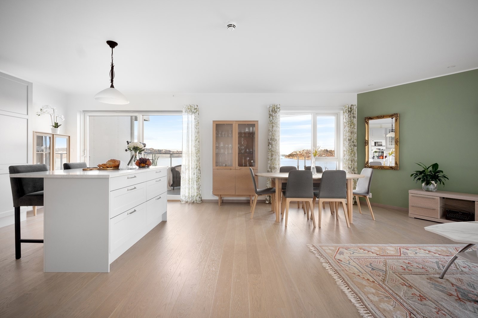 Det er god plass til spisebord i stuen, og kjøkkenøyen fungerer som en romdeler mellom kjøkken og stue. Galleribilde