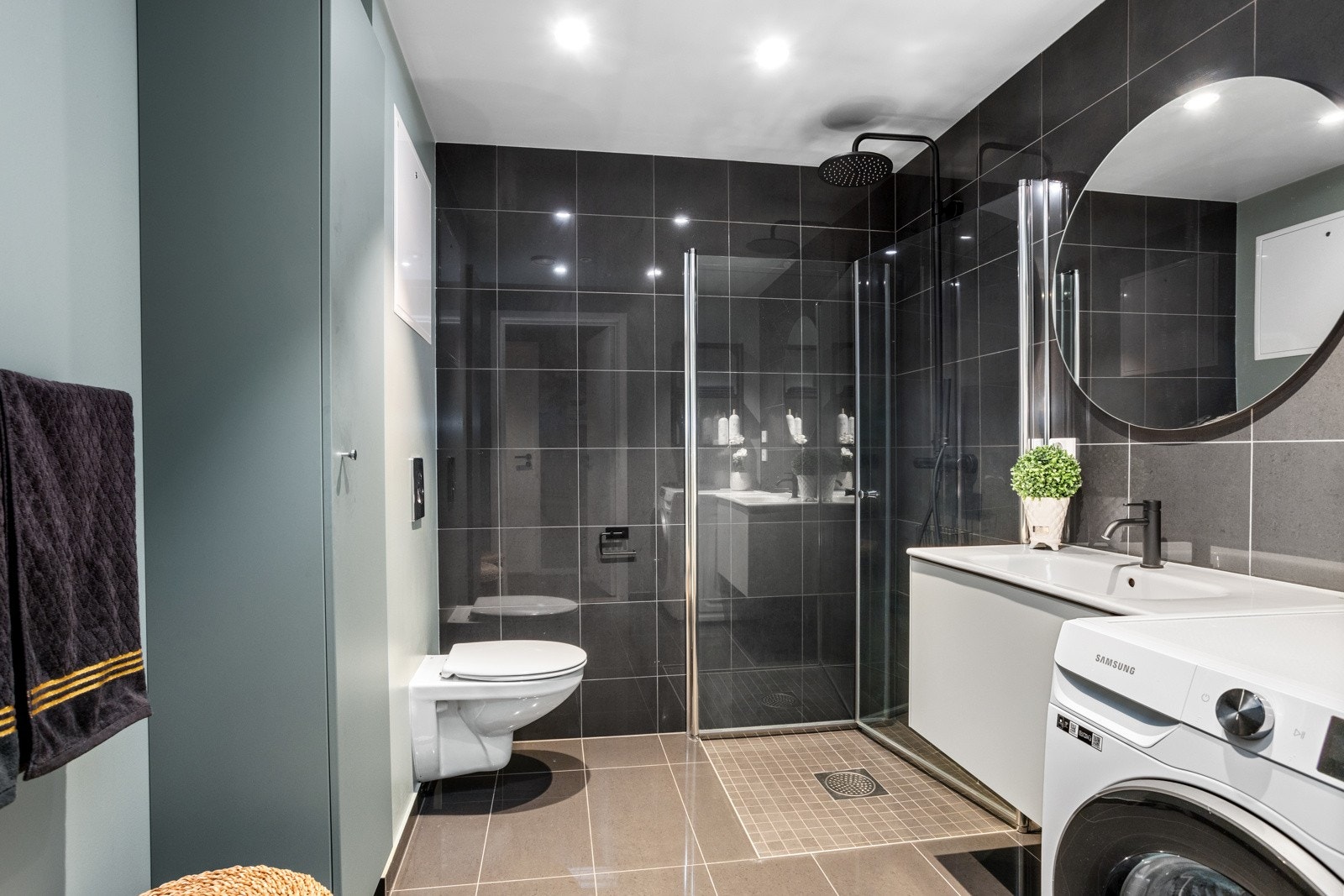 Lekkert bad/wc med storformat fliser og solid skapinnredning (strøm er lagt opp bak speilet til evt mer lys) Galleribilde