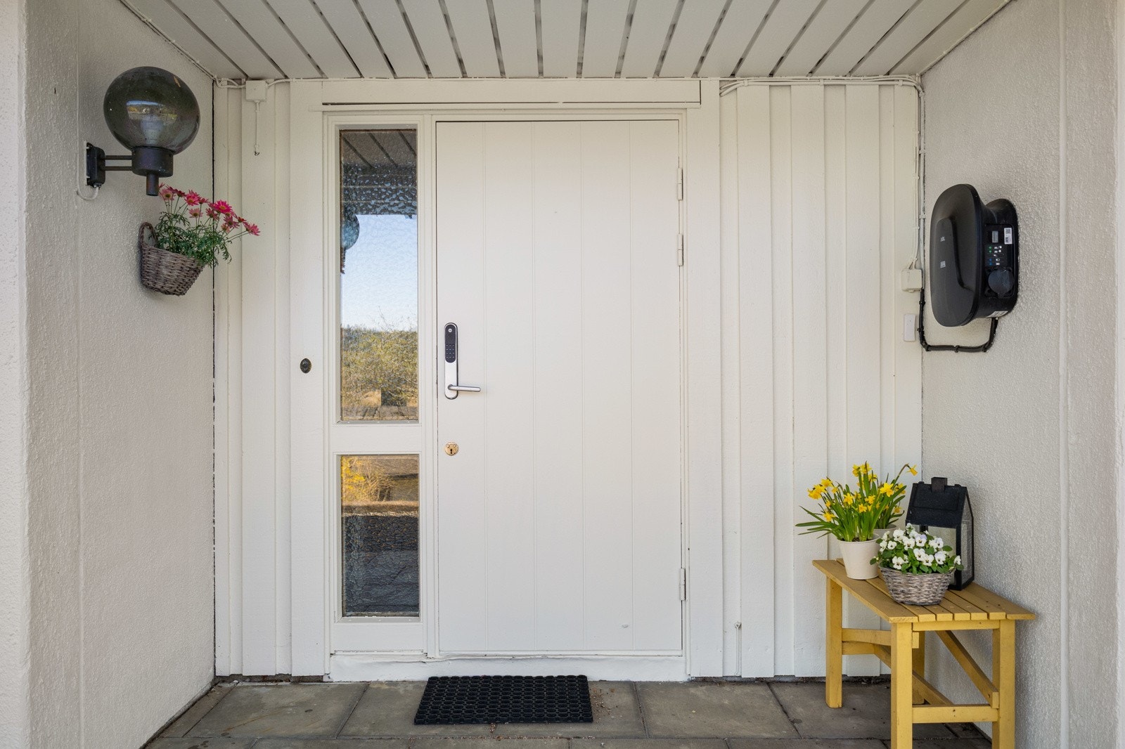 Hyggelig inngangsparti med elbillader på husveggen. Galleribilde