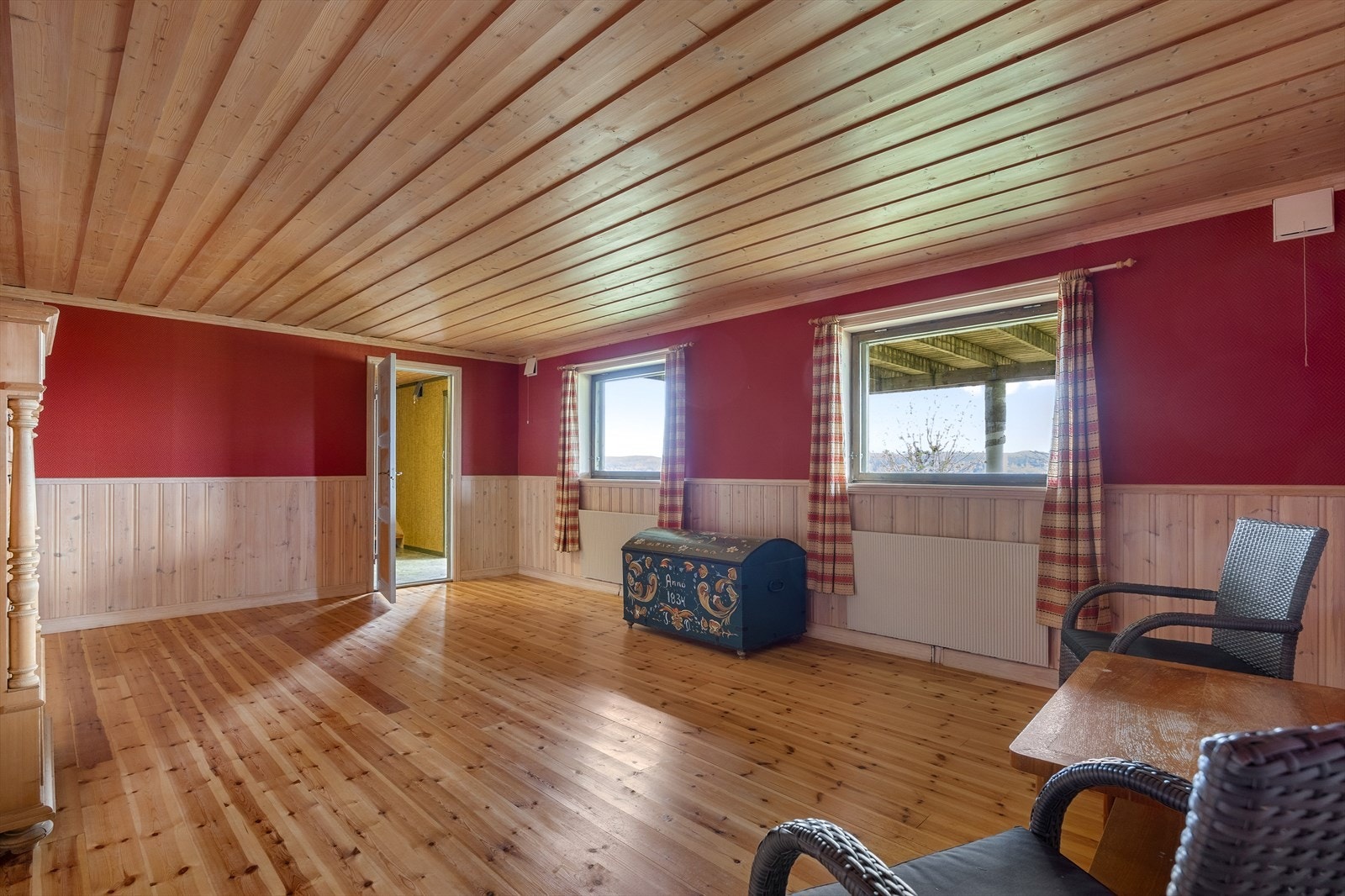 Kjellerstuen er av god størrelse, har tregulv og rødmalte vegger med trehvit brystningspanel. Galleribilde