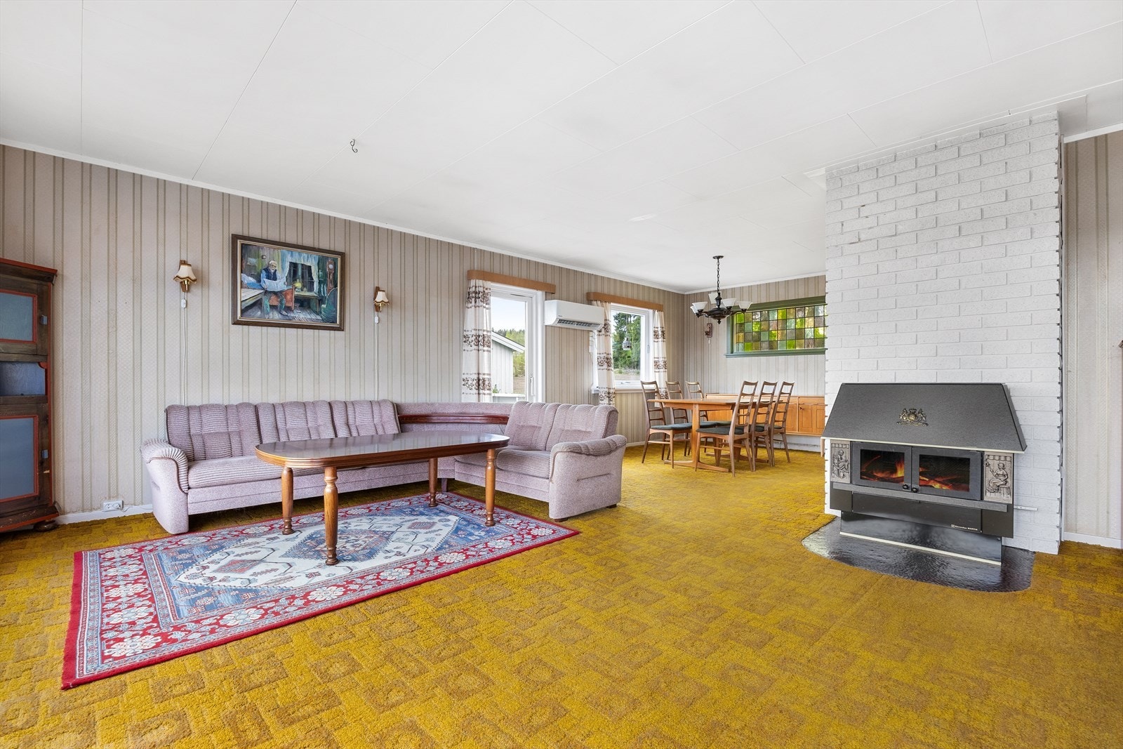 Rommet har stripete tapet på veggene og på gulvet er det teppe. Galleribilde