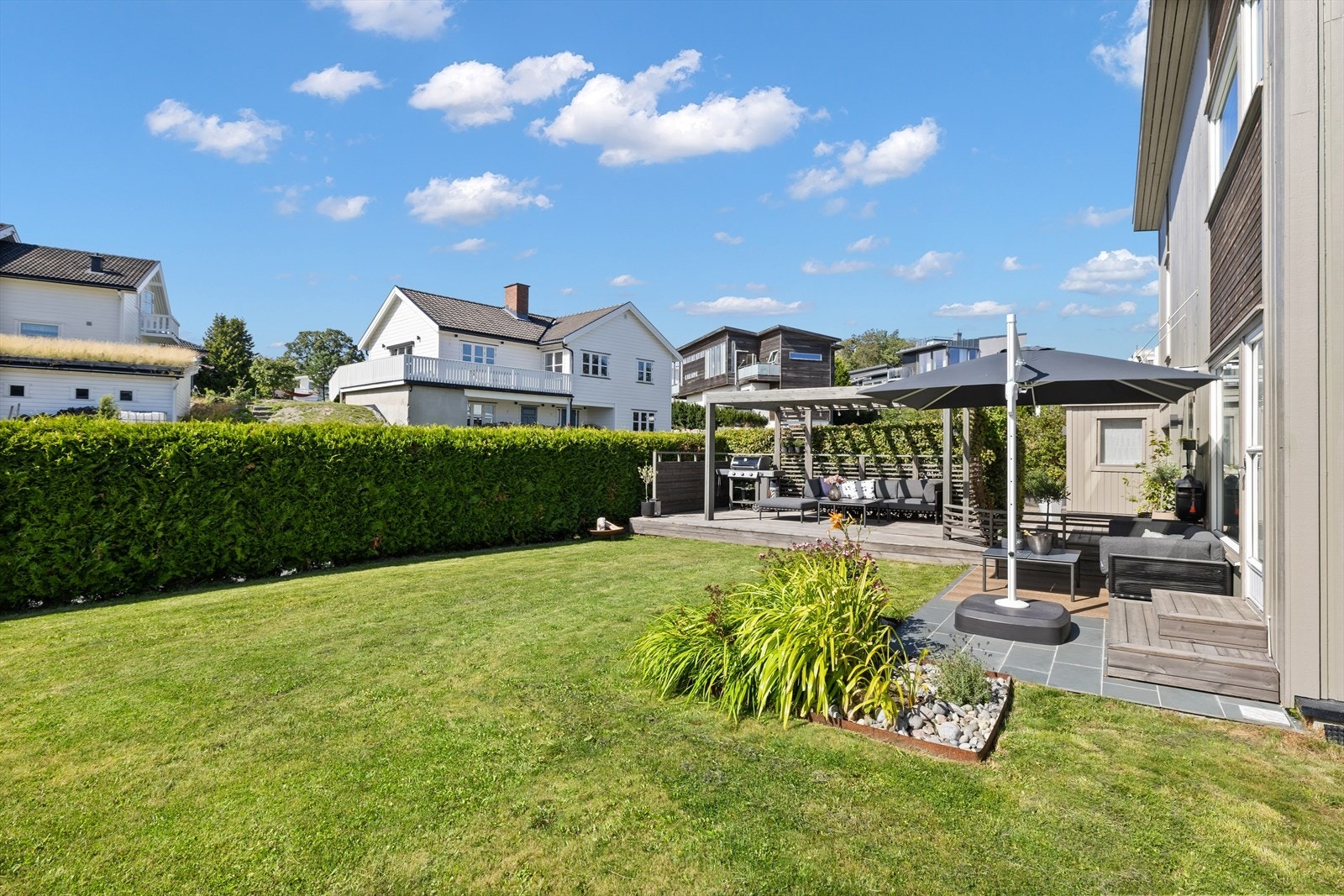 Boligen har en romslig hage med flere sitteplasser, godt tilpasset bruk i sommerhalvåret. Galleribilde