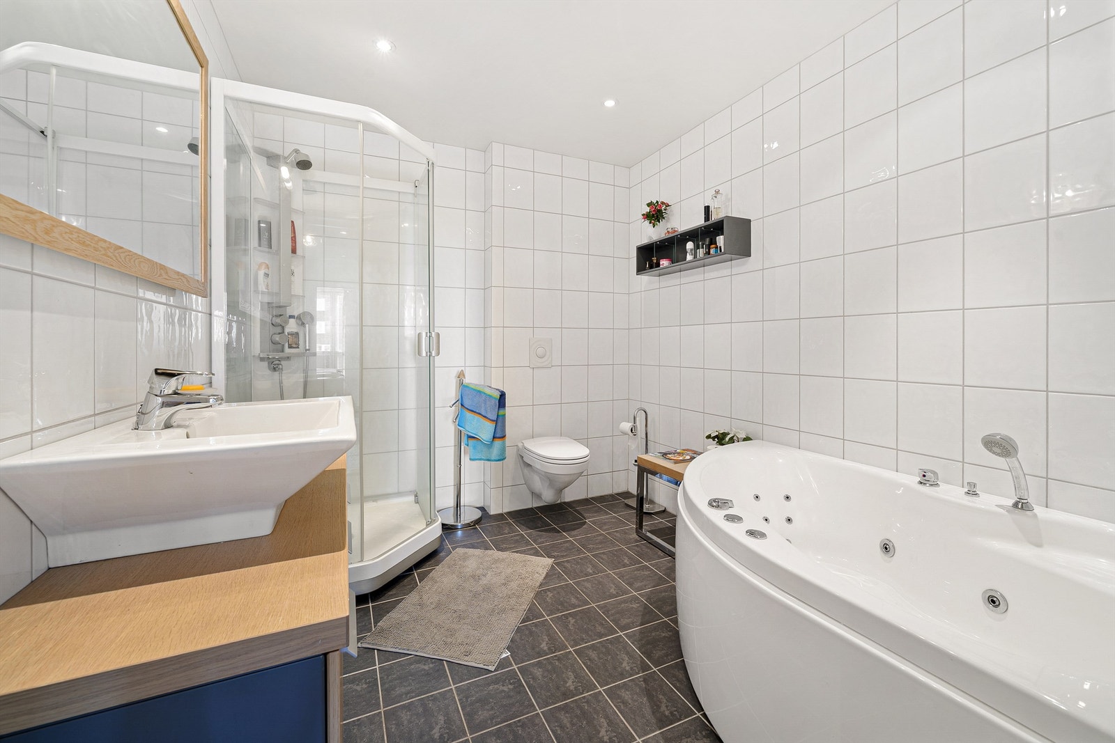 Bad av god størrelse med dusjkabinett, romslig innredning og boblebad Galleribilde