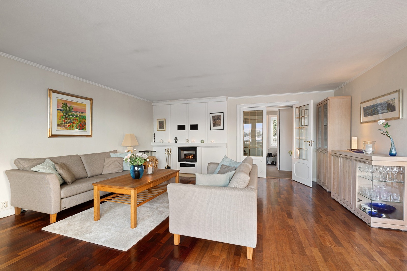 Det er god plass til en større sofagruppe og tilhørende møblement. Peisen er et naturlig midtpunkt i rommet og bidrar både med varme og stemning på kjølige kvelder. Galleribilde