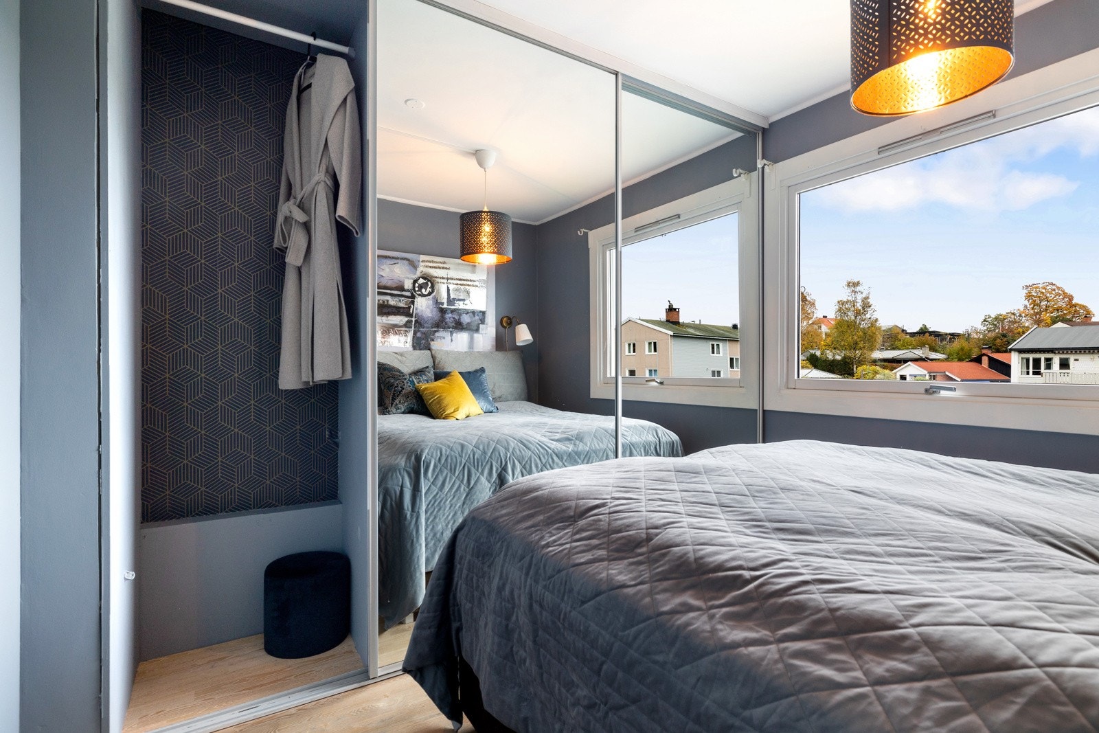 Langs den ene veggen er det en stor garderobeløsning med speilfronter som gir god oppbevaringsplass. Galleribilde