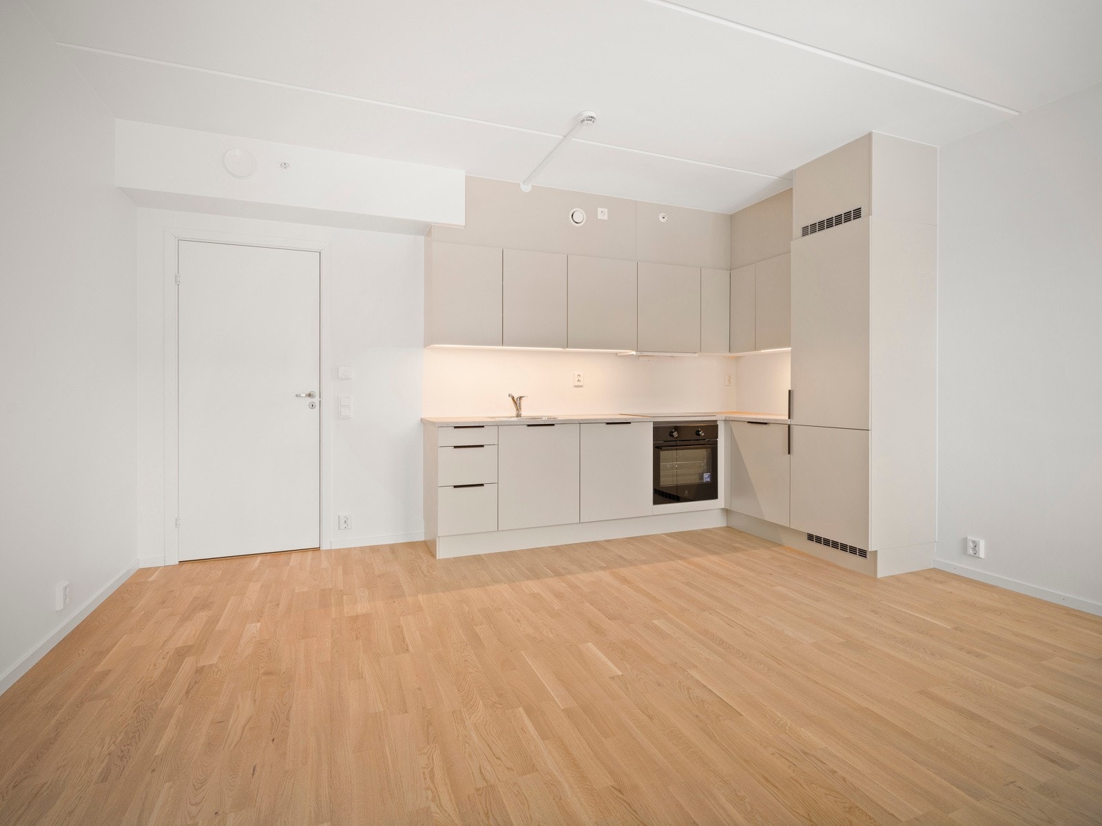 Stue med åpen kjøkkenløsning og utgang til balkong. Komplett utstyrt kjøkken med integrerte hvitevarer. Galleribilde