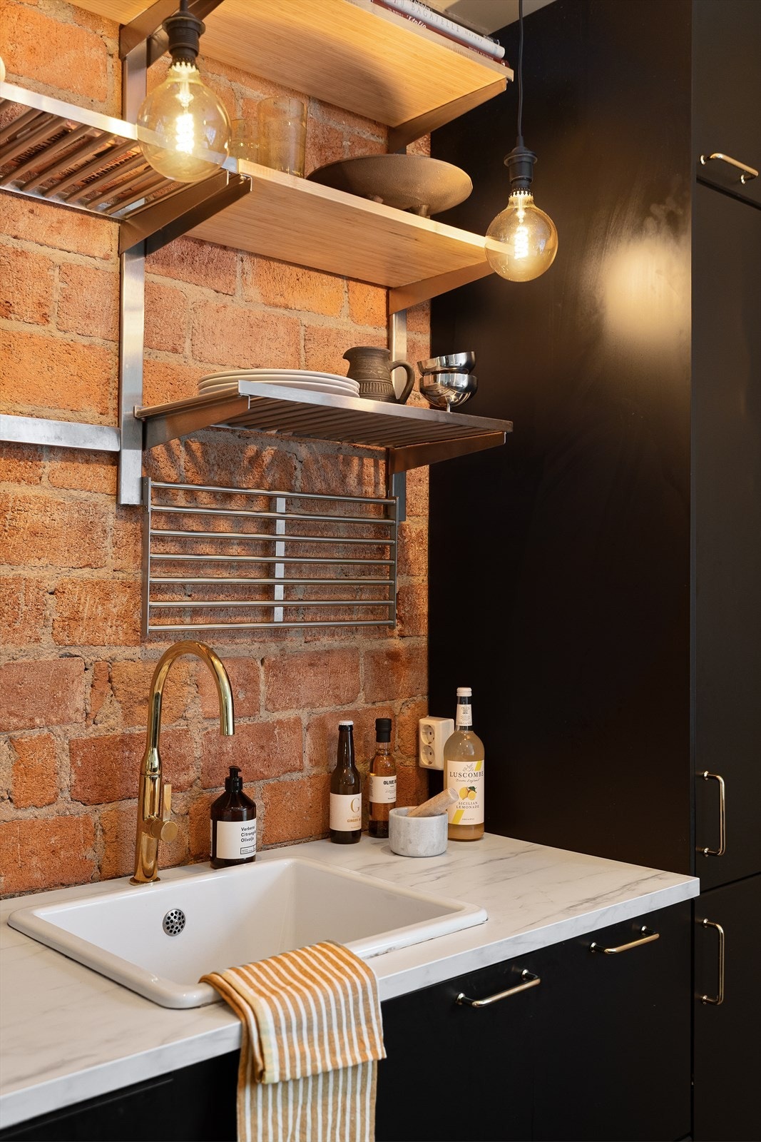 Den eksponerte teglsteinsvegg gir leiligheten "det lille ekstra" Galleribilde