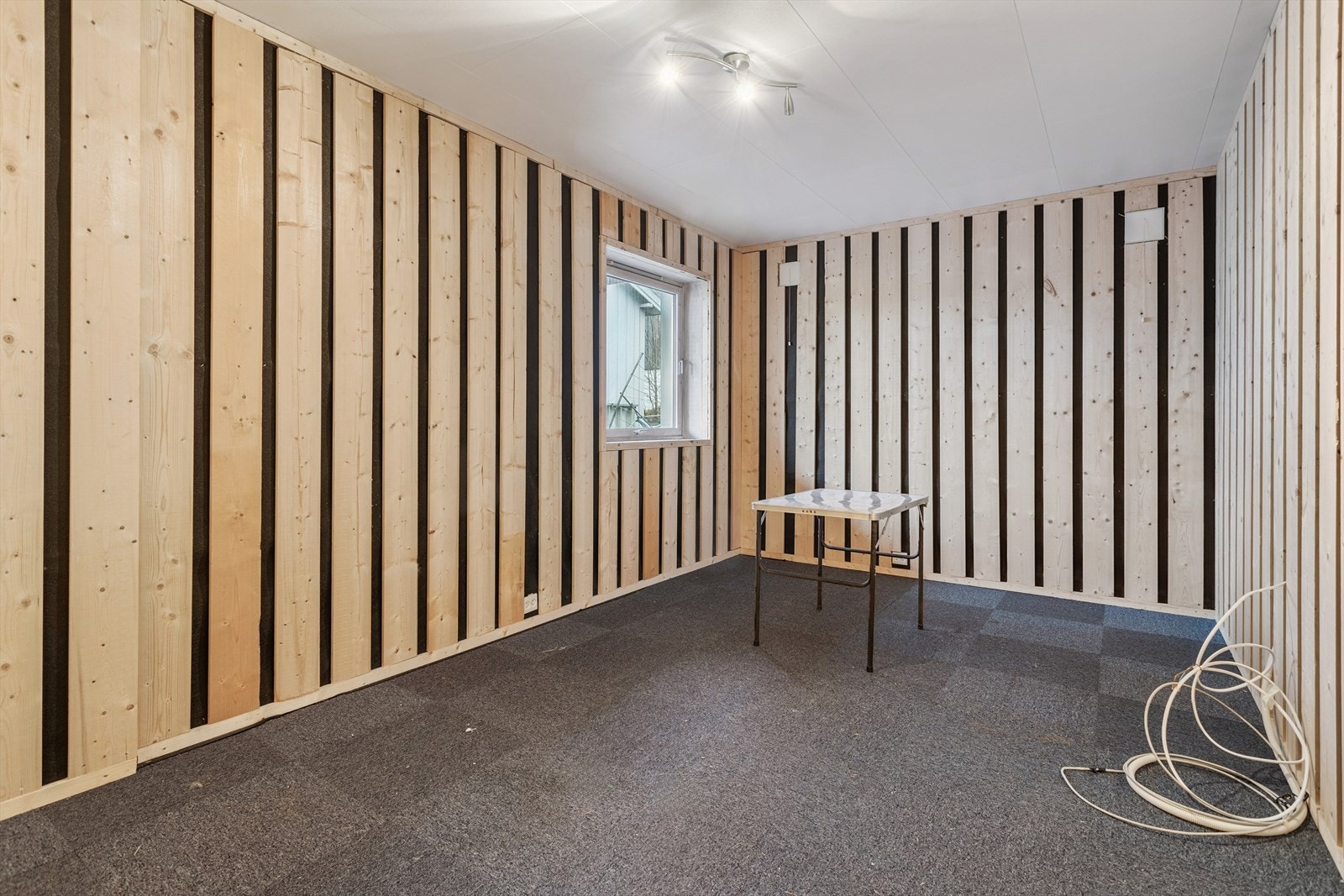 Ett av soverommene i kjelleren er innredet med vegger i spaltet trekledning. Galleribilde