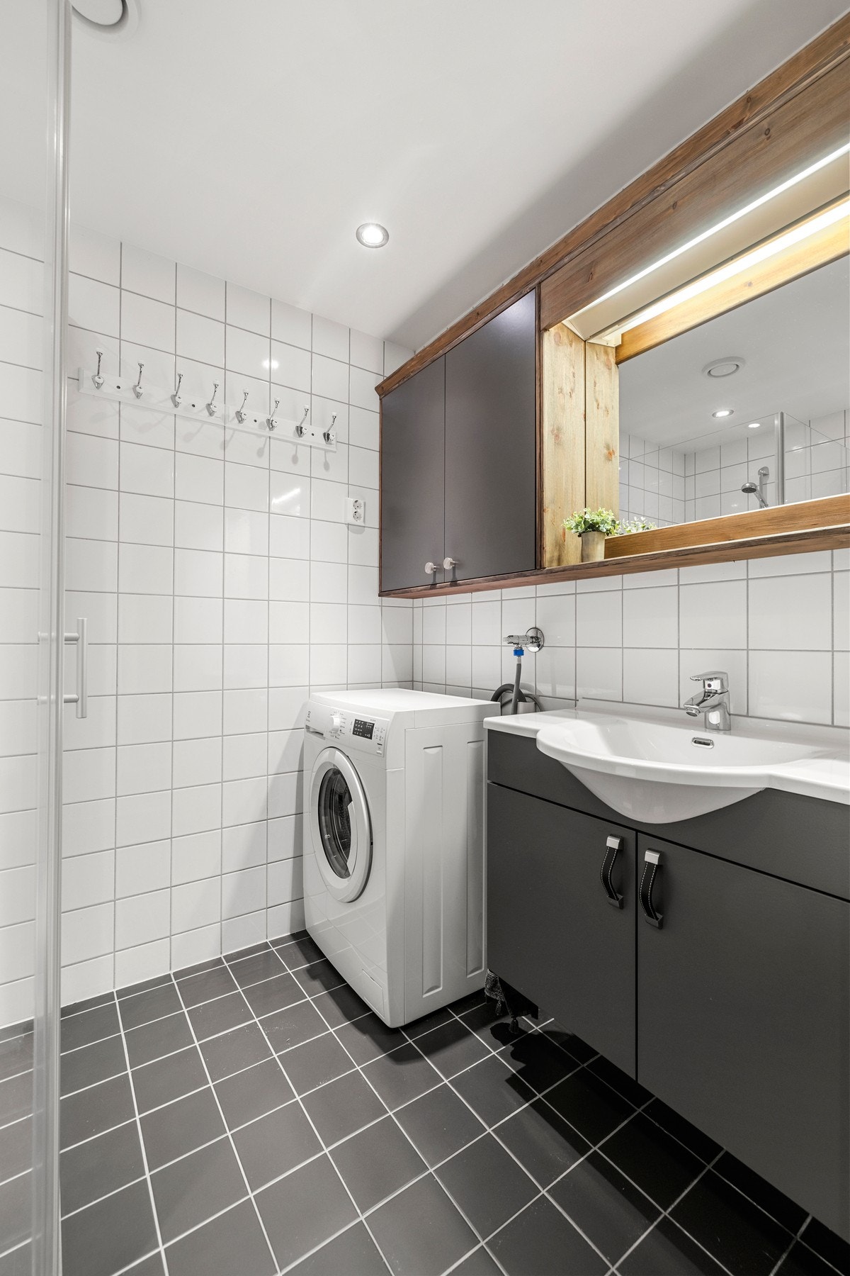 Praktisk innredning med servant, speilskap og plass til vaskemaskin.. Galleribilde