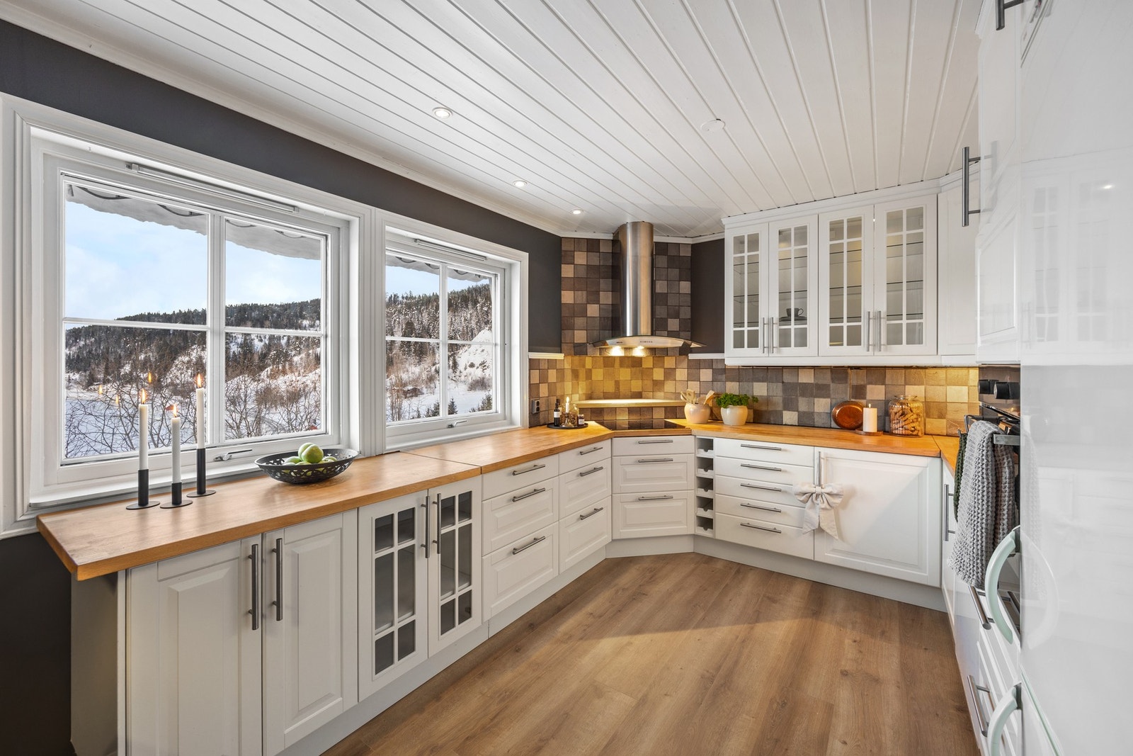 Stilren kjøkkeninnredning med integrert stekeovn, platetopp og oppvaskmaskin, samt avsatt plass for kjøleskap Galleribilde