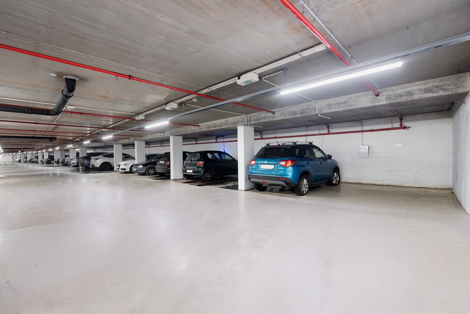 Det tilhører parkeringsplass/biloppstillingsplass på i felles kjellergarasje. Her er det satt opp en El-billader. Galleribilde