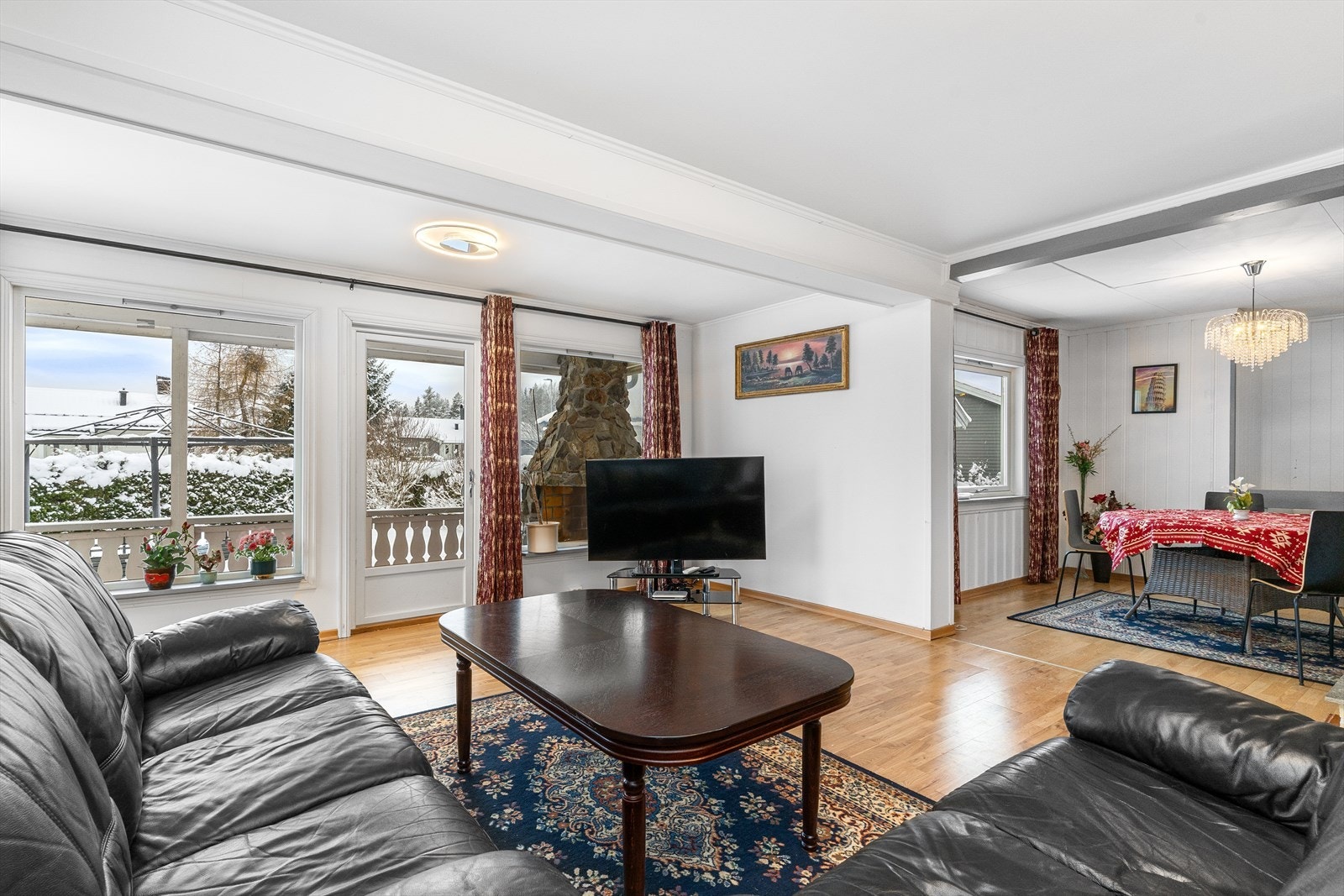 Stuen er romslig og lys med parkett på gulv og malte plater på vegg. Galleribilde