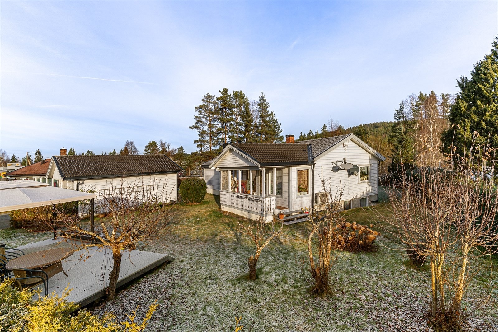 Dels flat/ skrånet tomt. Opparbeidet med gressplen og beplantning. Gruset gårdsplass. Galleribilde