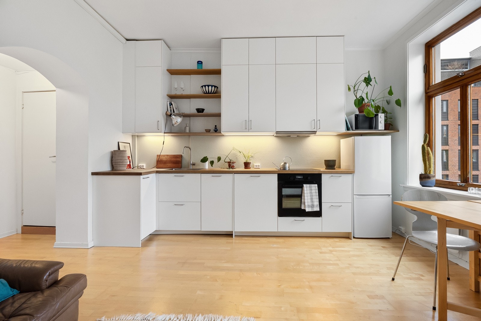 Kjøkkenet ble flyttet fra dagens alkove til stuen og etablert på nytt i 2024. Innredning fra IKEA med hvite slette fronter og benkeplate i tre. Galleribilde