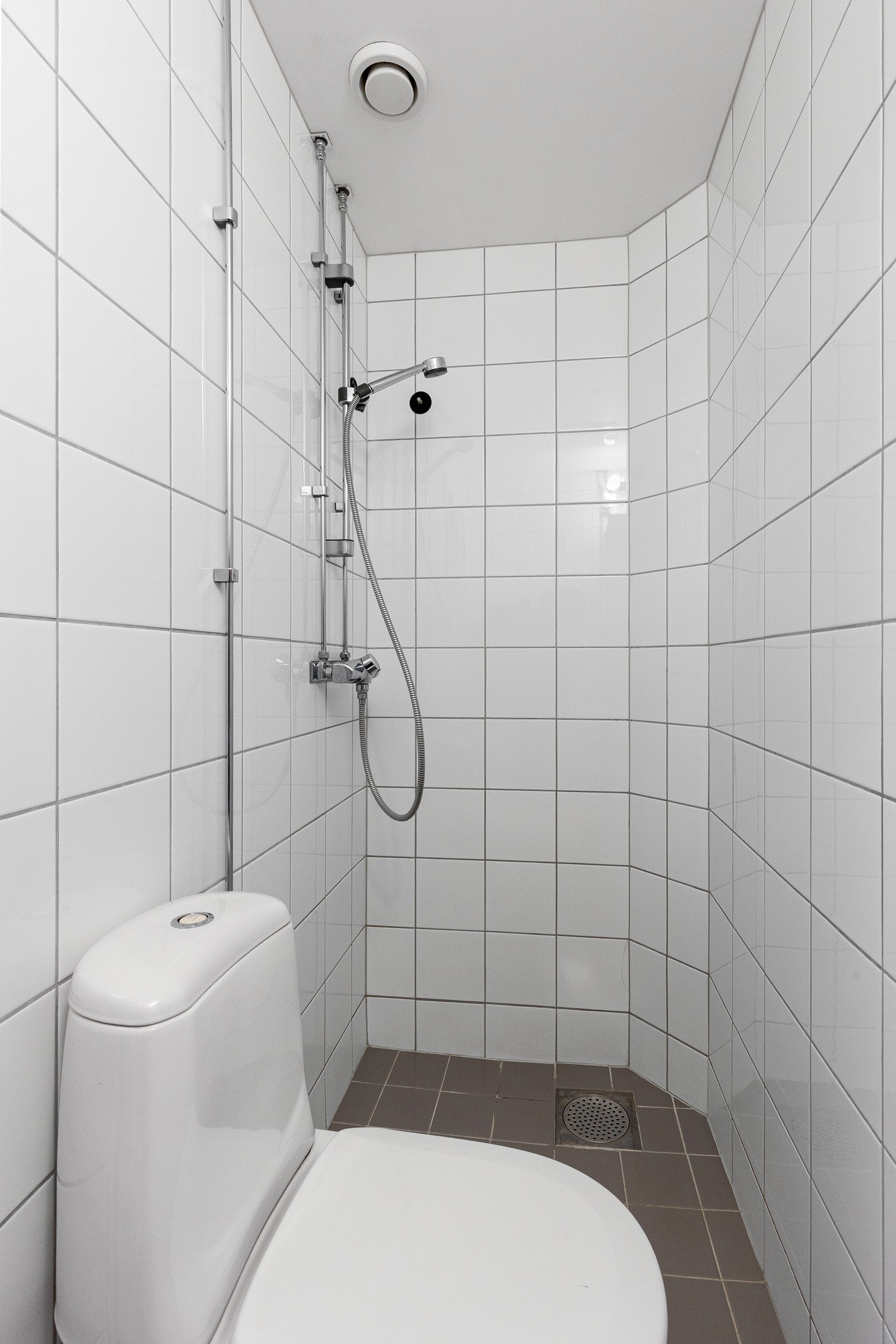 Badet er utstyrt med servant, speilskap med overbelysning og stikkontakt, toalett og dusj. Galleribilde