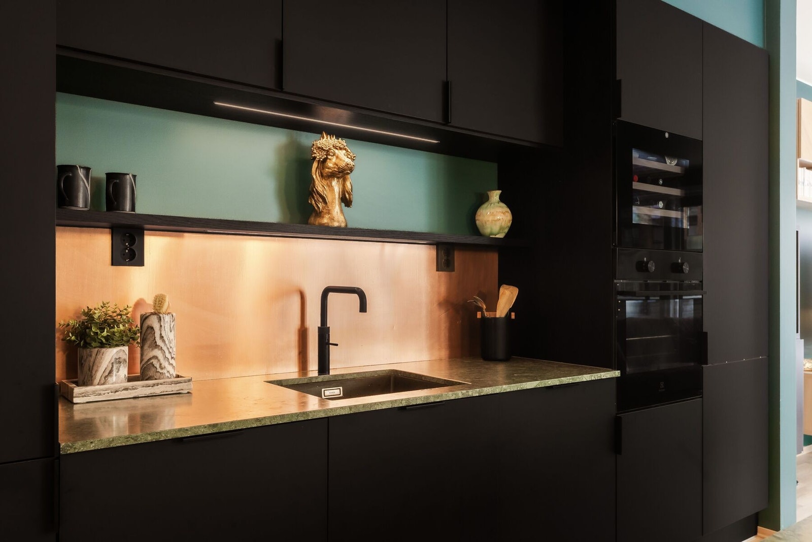 Kjøkkenet er fullt utstyrt med vinskap, kjøleskap, fryseskap, ekstra kjøleskuff, sokkelskuffer og Quooker - alt sømløst integrert for et stilrent uttrykk. Galleribilde