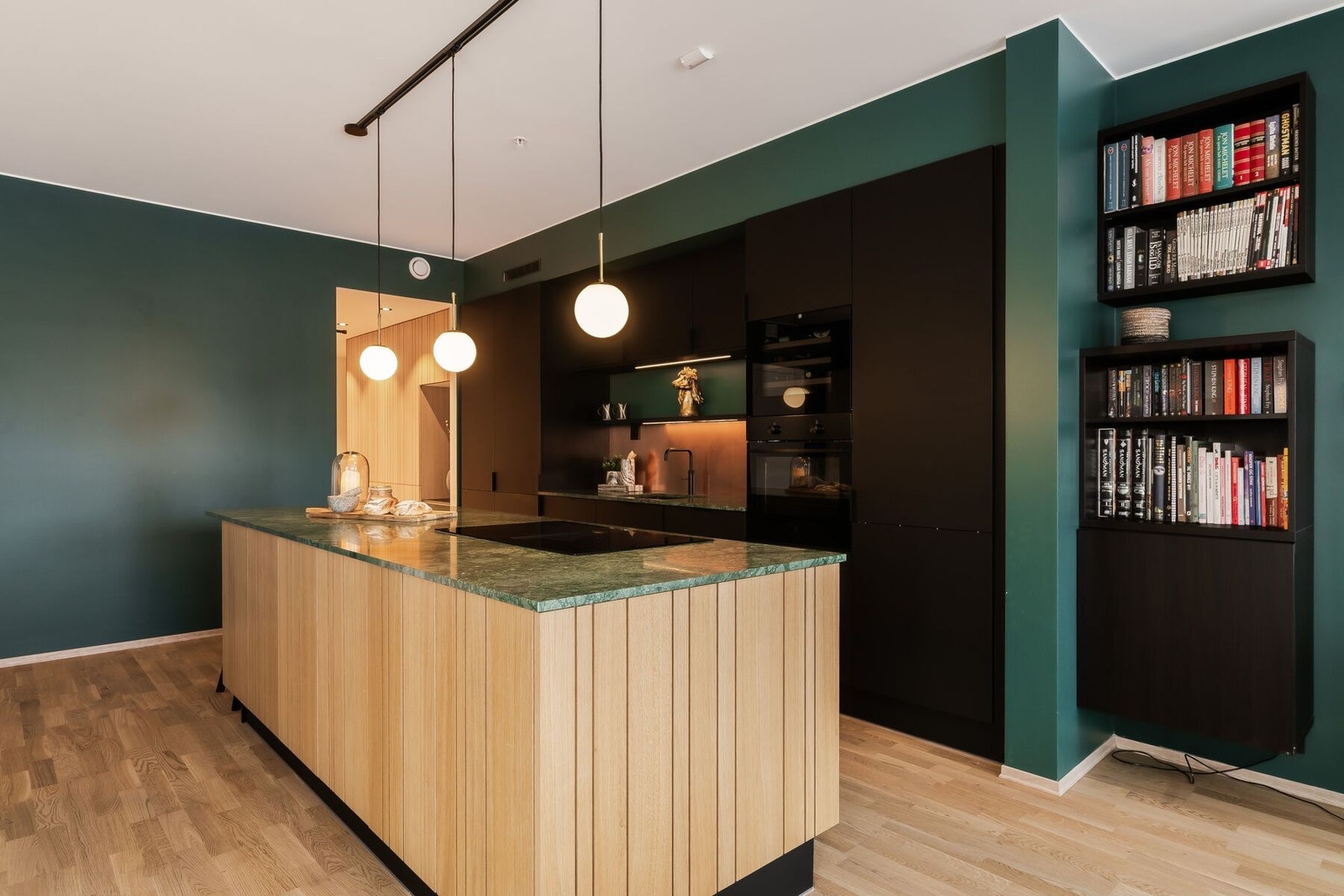 Den store kjøkkenøya fungerer som et naturlig midtpunkt - med induksjonstopp integrert i øyen, skap på begge sider og sitteplass til to. Galleribilde