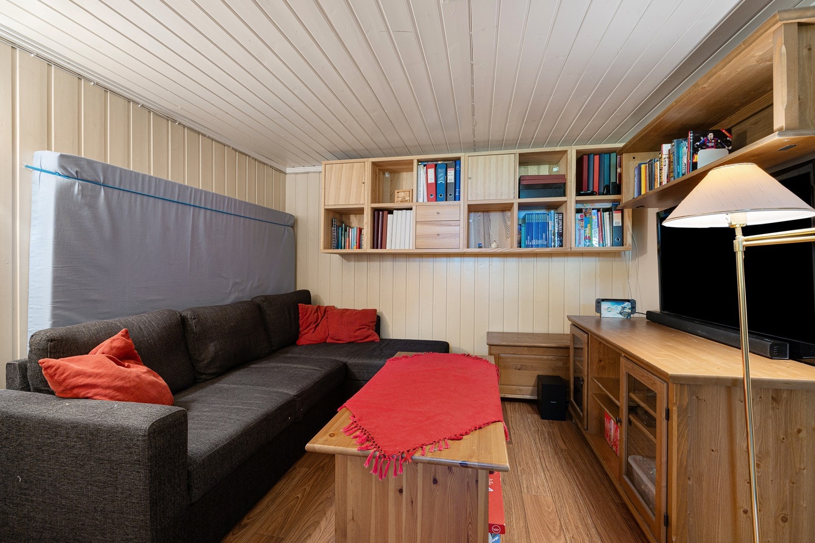 Rommet har lysmalt panel på veggene og gyllent laminat på gulvet. Galleribilde