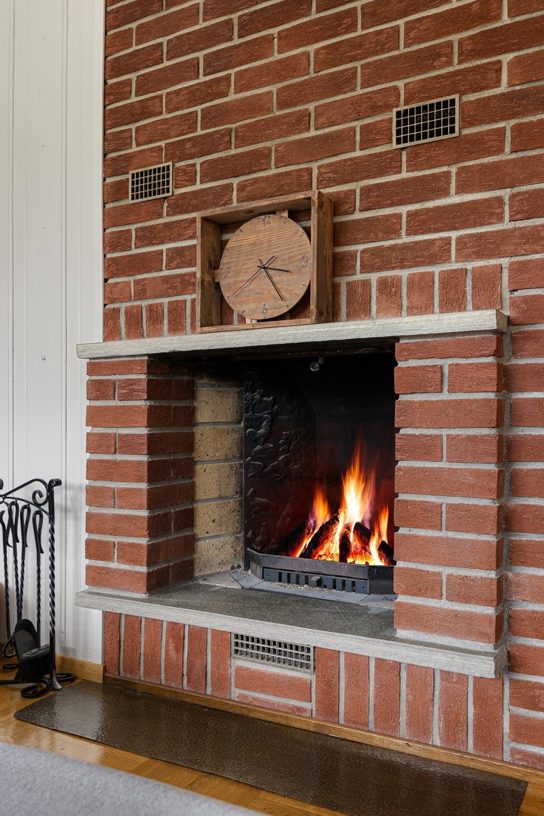 I en mursteinskledd vegg er det en åpen peis som bidrar ekstra til hygge og varme. Galleribilde