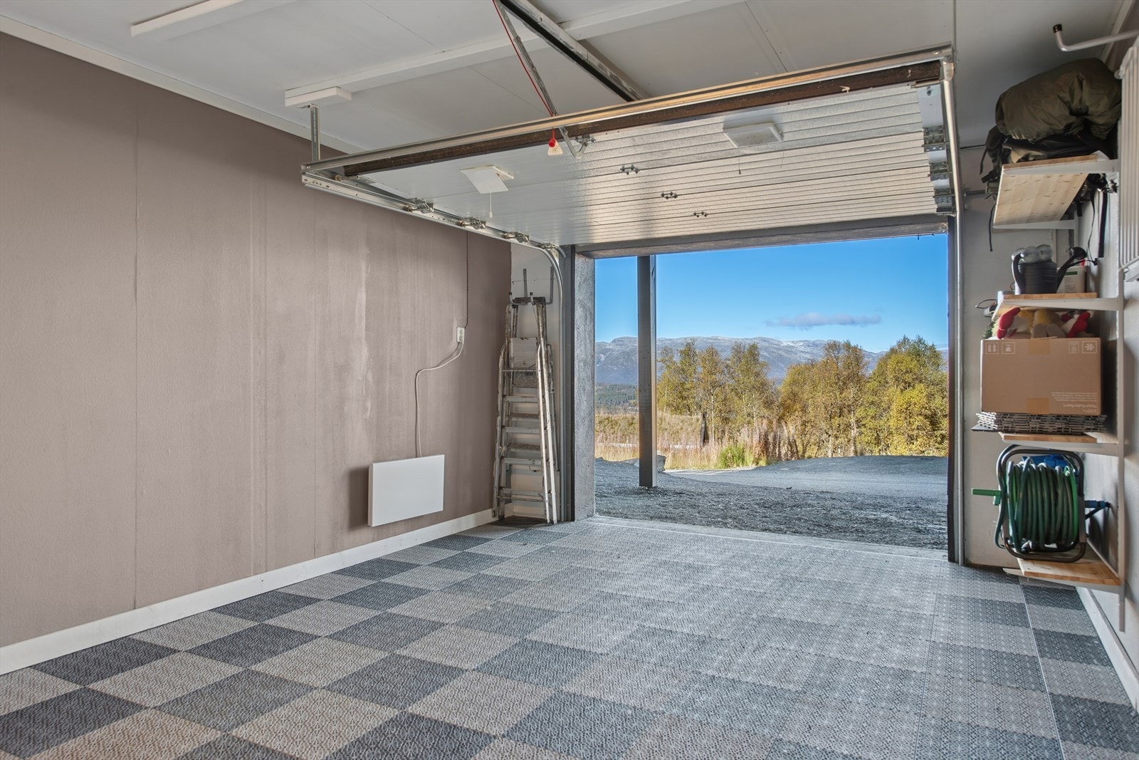 Garasje i underetasjen med plass til én bil samt oppbevaring av ved og ski. Det er i tillegg opparbeidet parkeringsplass på tomten. Galleribilde