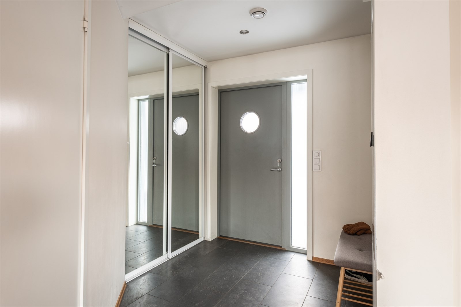Entréen gir et ryddig og innbydende førsteinntrykk, med god plass til yttertøy og sko i skyvedørsgarderobe med speilfronter. Galleribilde